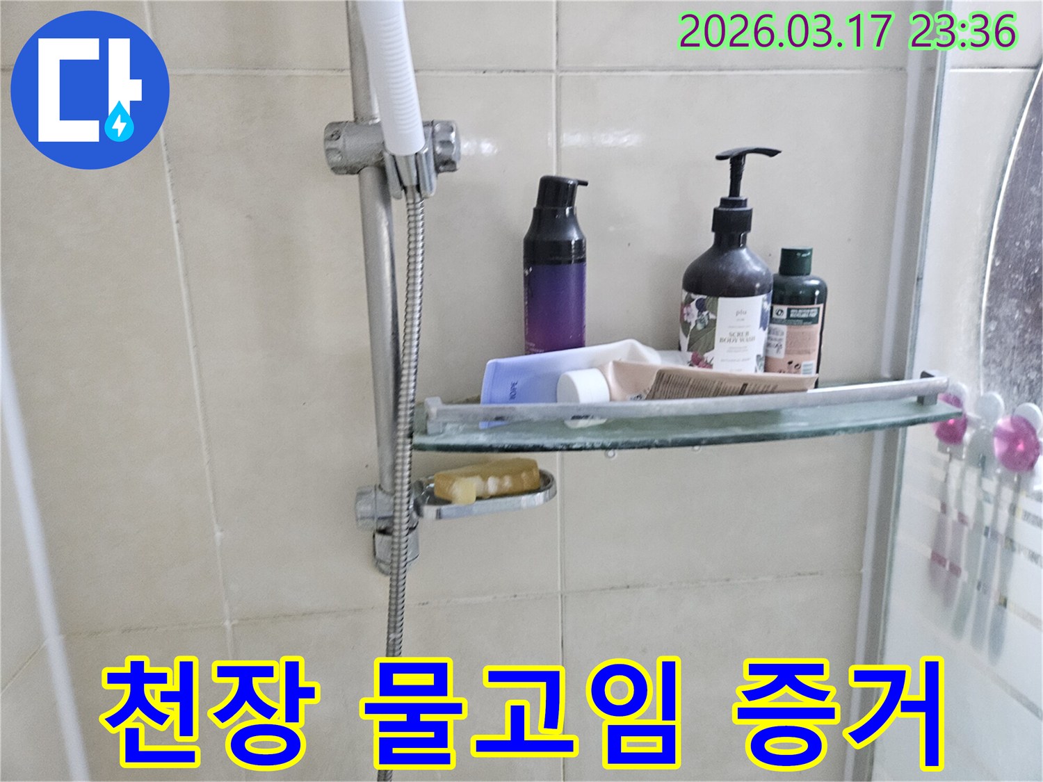 욕실 샤워기 옆-유리 선반에 맺힌 물방울은-천장 누수의 간접적인 증거를 보여주는 이미지입니다