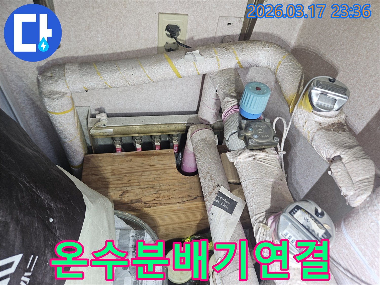 주택-보일러실-온수-분배기-연결부에서-발생한-누수를-해결하기-위해-연결부를-재시공하는-전문가
