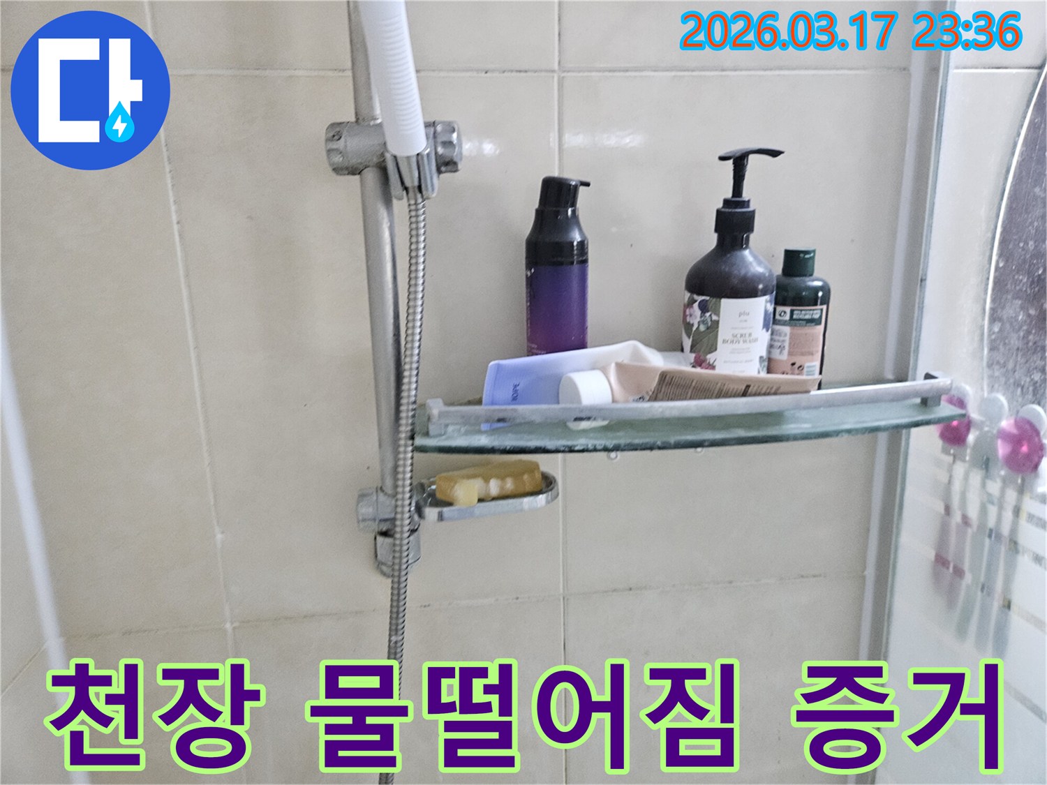 화장실 샤워기 옆-유리 선반에 맺힌 물방울은-천장 누수의 간접적인 증거를 보여주는 이미지입니다