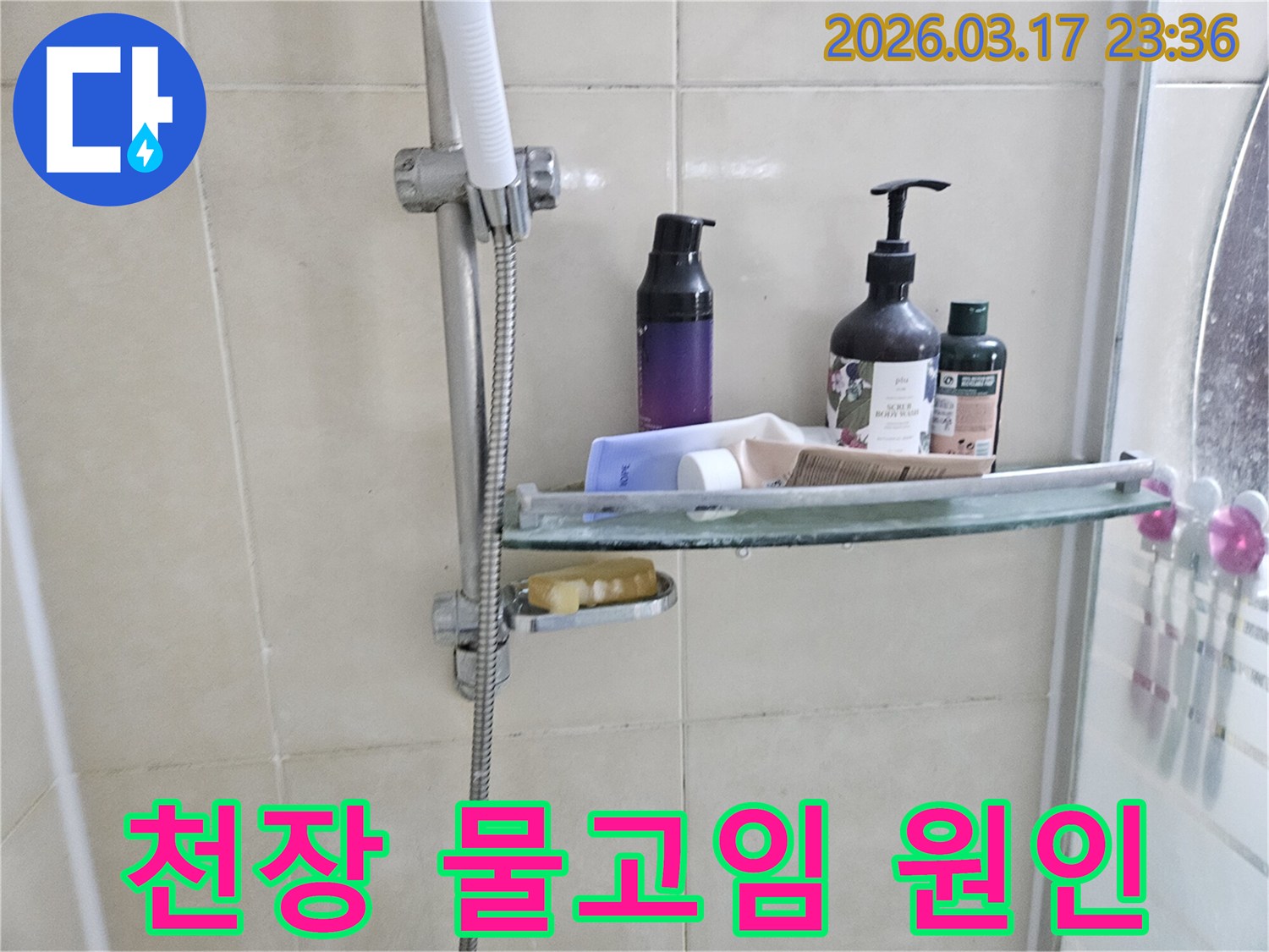 화장실 샤워기 옆-유리 선반에 맺힌 물방울은-천장 물고임의 간접적인 증거를 보여주는 이미지입니다