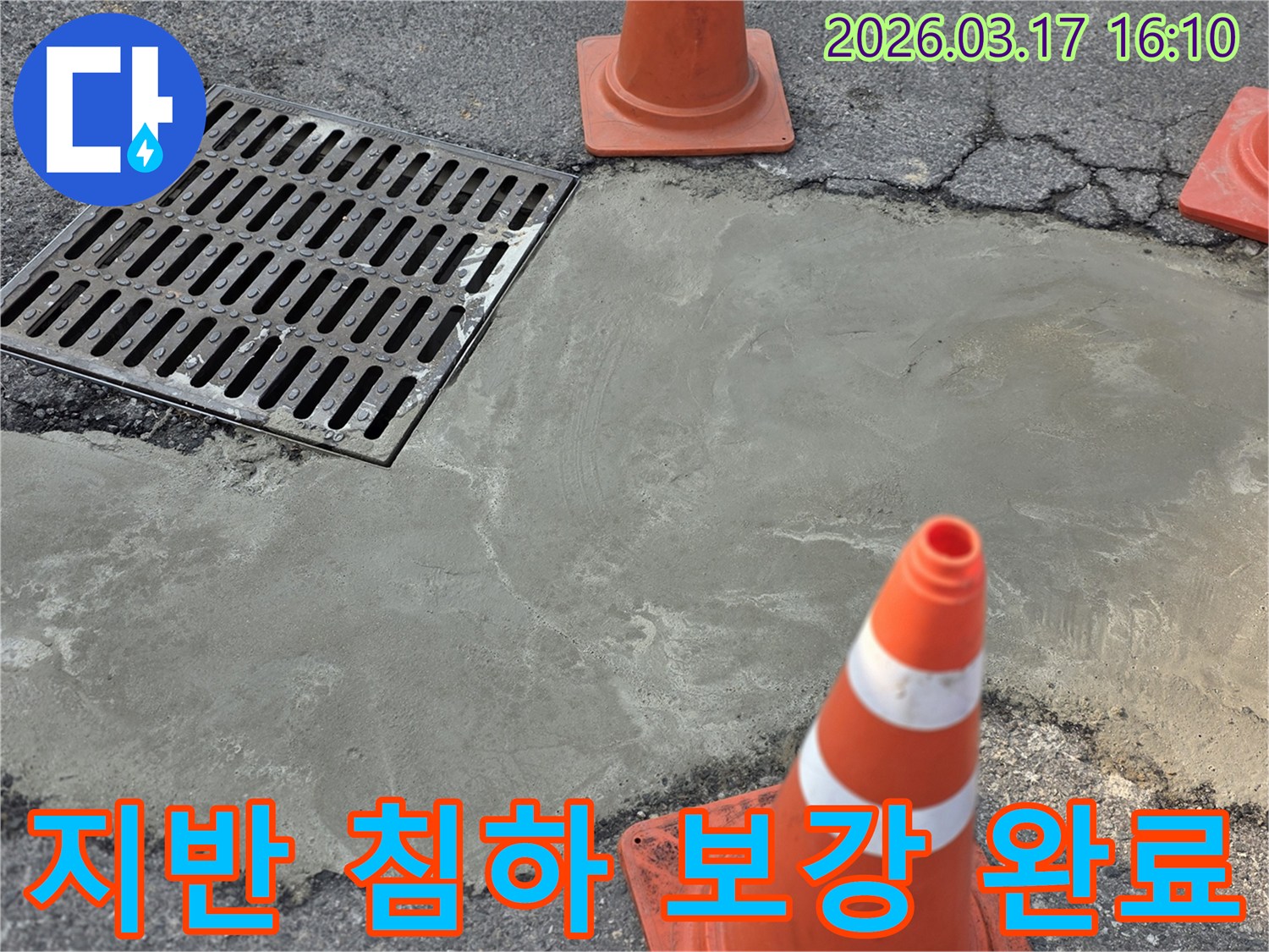 이 이미지는 양주 율정동의 외부 지반 침하로 인한 누수 문제를 해결하고-새로운 시멘트 마감으로 보강된 현장을 보여주며-안전 콘이 설치되어 있습니다.