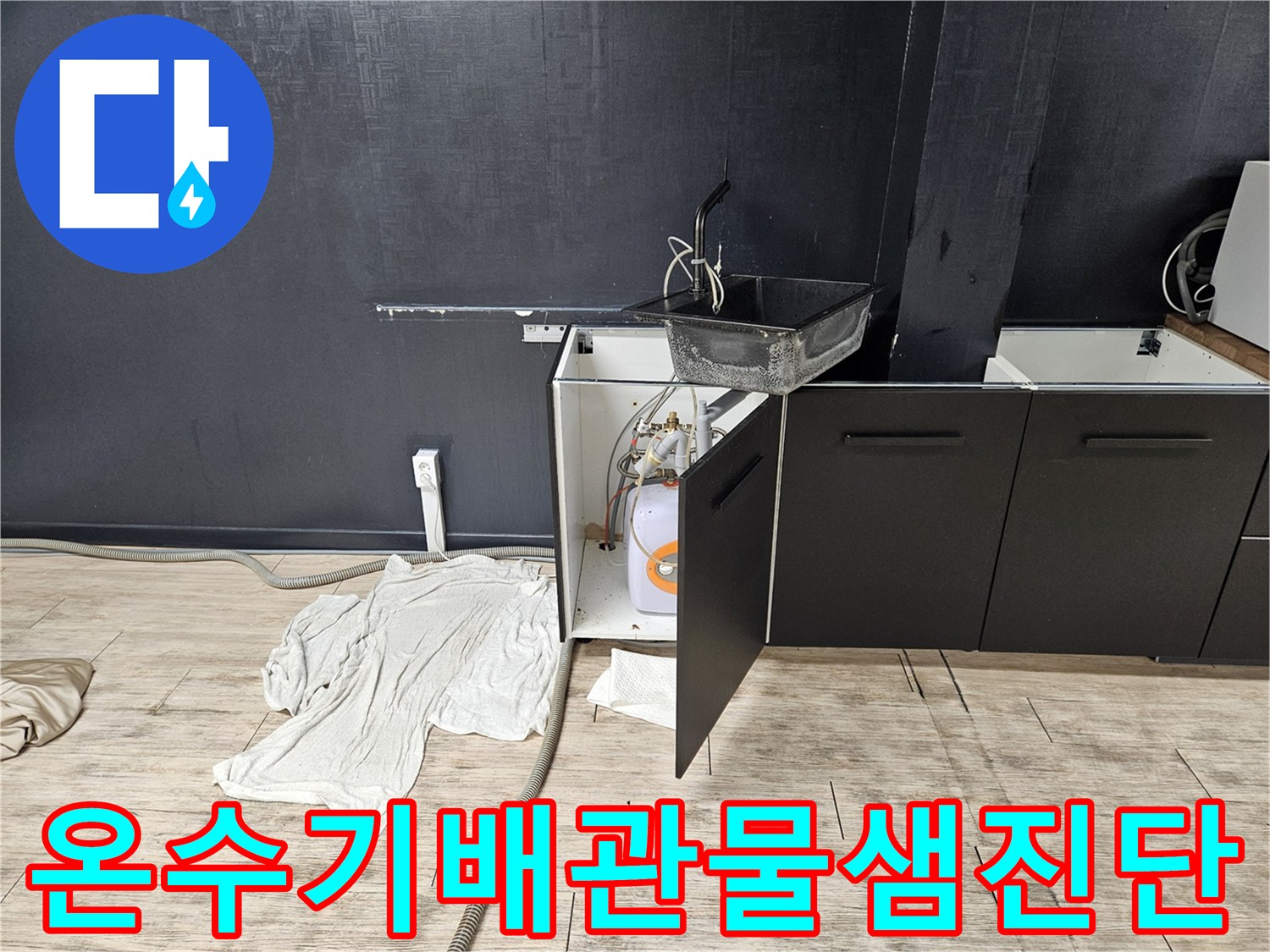 하부장-내부에-노출된-전기-온수기와-연결된-급수-배관의-점검-모습