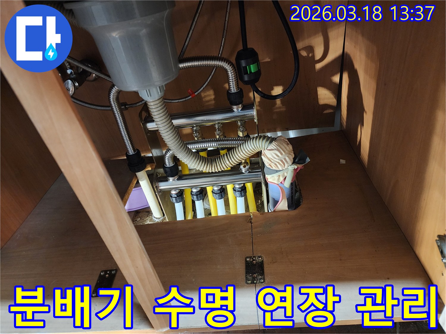 싱크대 하부 보일러 분배기의-수명을 연장하고-효율을 높이기 위한-관리법을 설명하며-점검하는 모습입니다