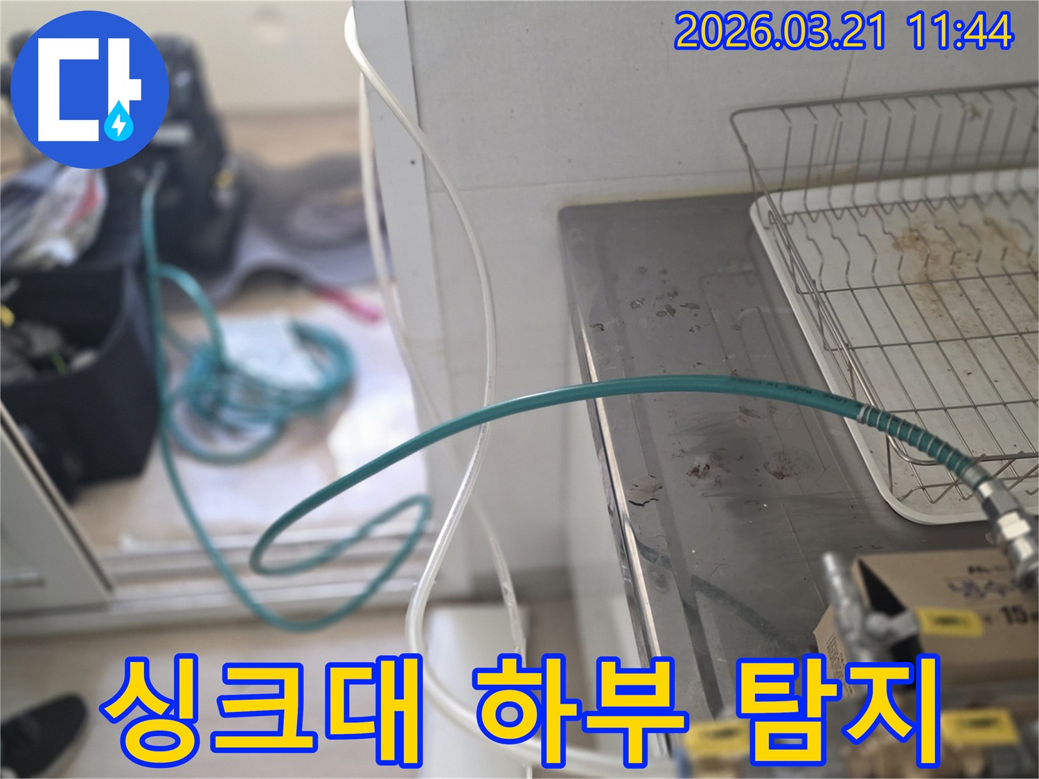 누수 엔지니어가-아파트 싱크대 하부 배관에서-누수탐지 장비를 연결하고 있는 장면입니다