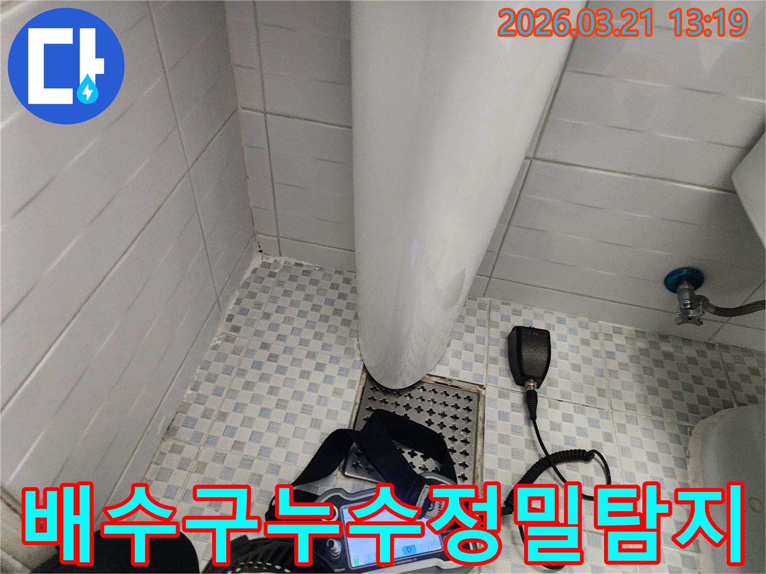 화장실-배수구-주변에서-누수탐지-장비를-이용해-누수-지점을-정밀하게-찾는-전문가의-모습