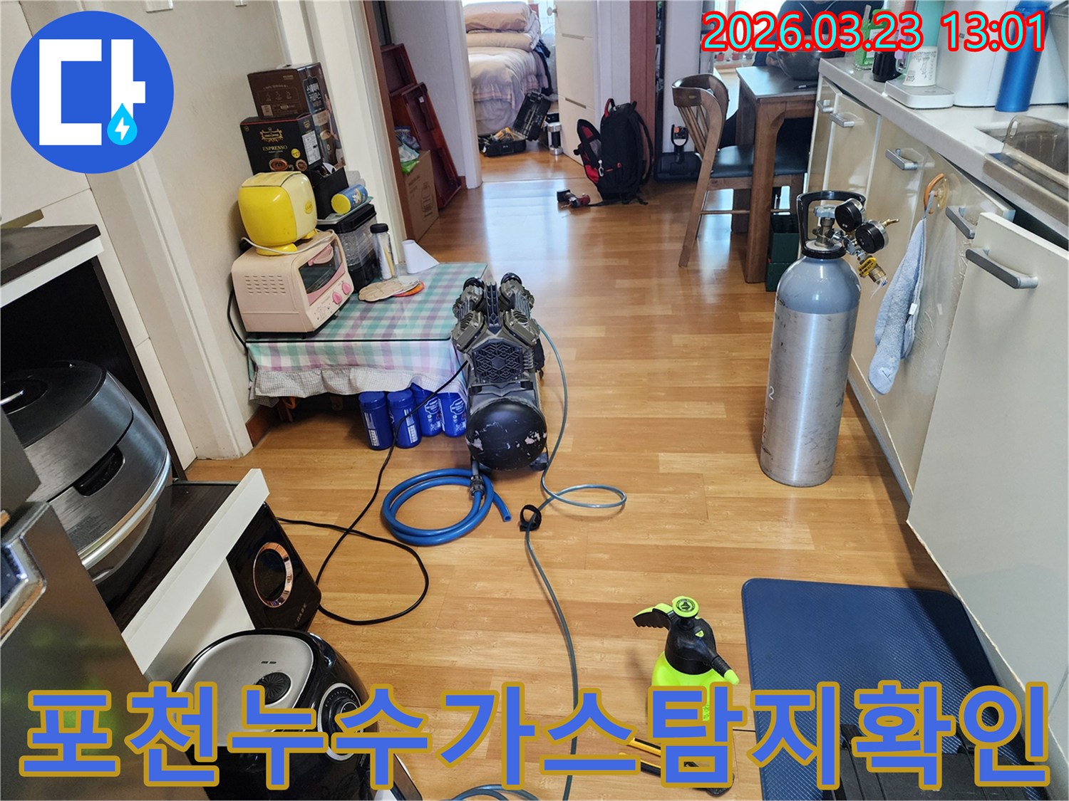 빌라 내부에서 미세 누수를 확인하기 위해-가스 탐지 장비와 가스 실린더를 연결하고-작업을 준비하는 모습