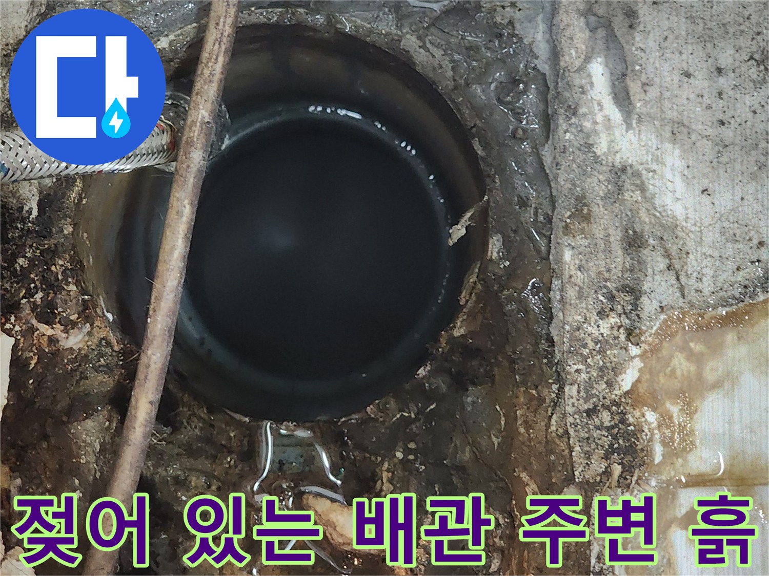 배관 주변의 젖은 토사와 습기를 보여주는 작업 현장 사진입니다.