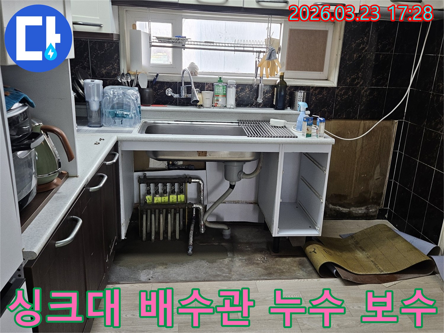 싱크대 하부에서 배수관 누수가 발생하여-긴급 보수를 위해 점검하는 모습