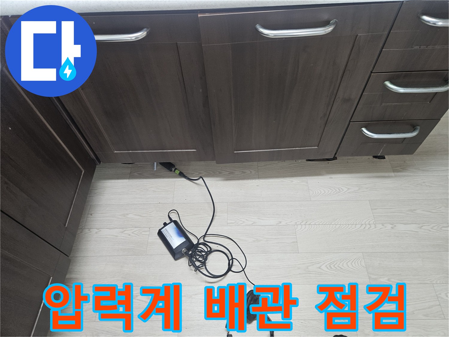 싱크대 하부장 아래 설치된 디지털 압력계와 연결된 검사용 배관