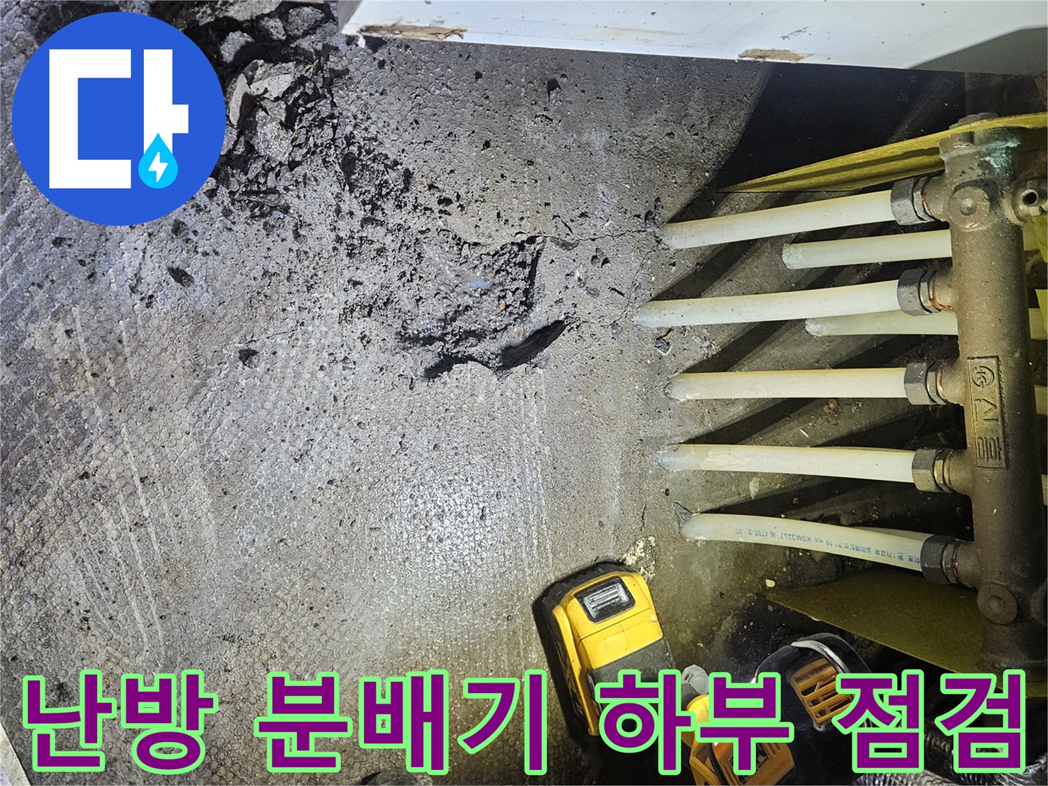 조명등 아래 드러난 난방 분배기와 젖은 배관 주변 부위