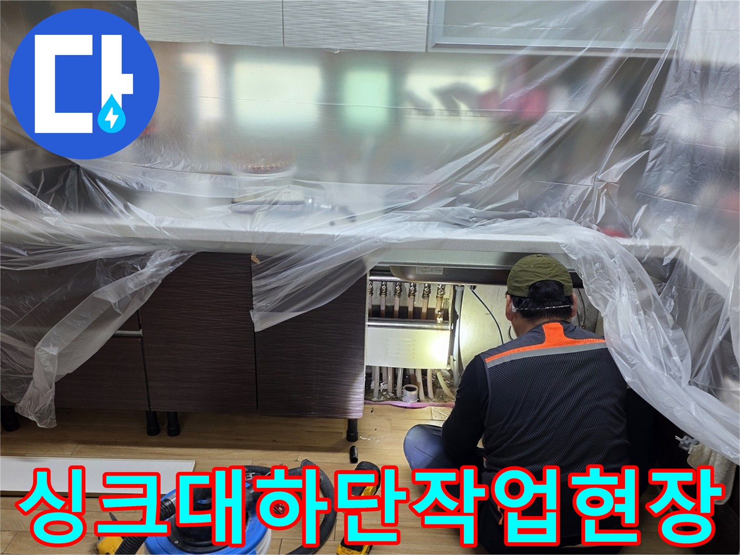 비닐로-보양된-싱크대-하부장에서-누수-진단을-진행하는-모습