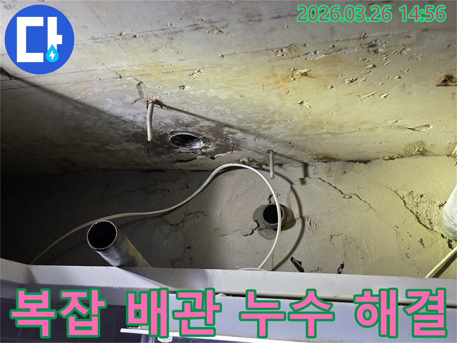 이 이미지는-복잡하게 얽힌-천장 배관에서 발생한-누수 문제를-전문적으로 해결하는-공사 현장을 보여줍니다.
