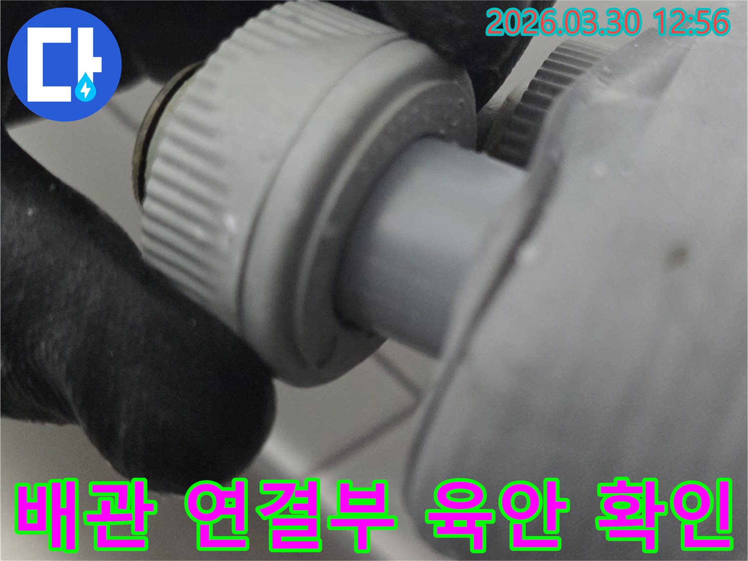 누수 발생 여부를 확인하기 위해 배관 연결 부위를 육안으로 꼼꼼히 살피는 전문가의 손