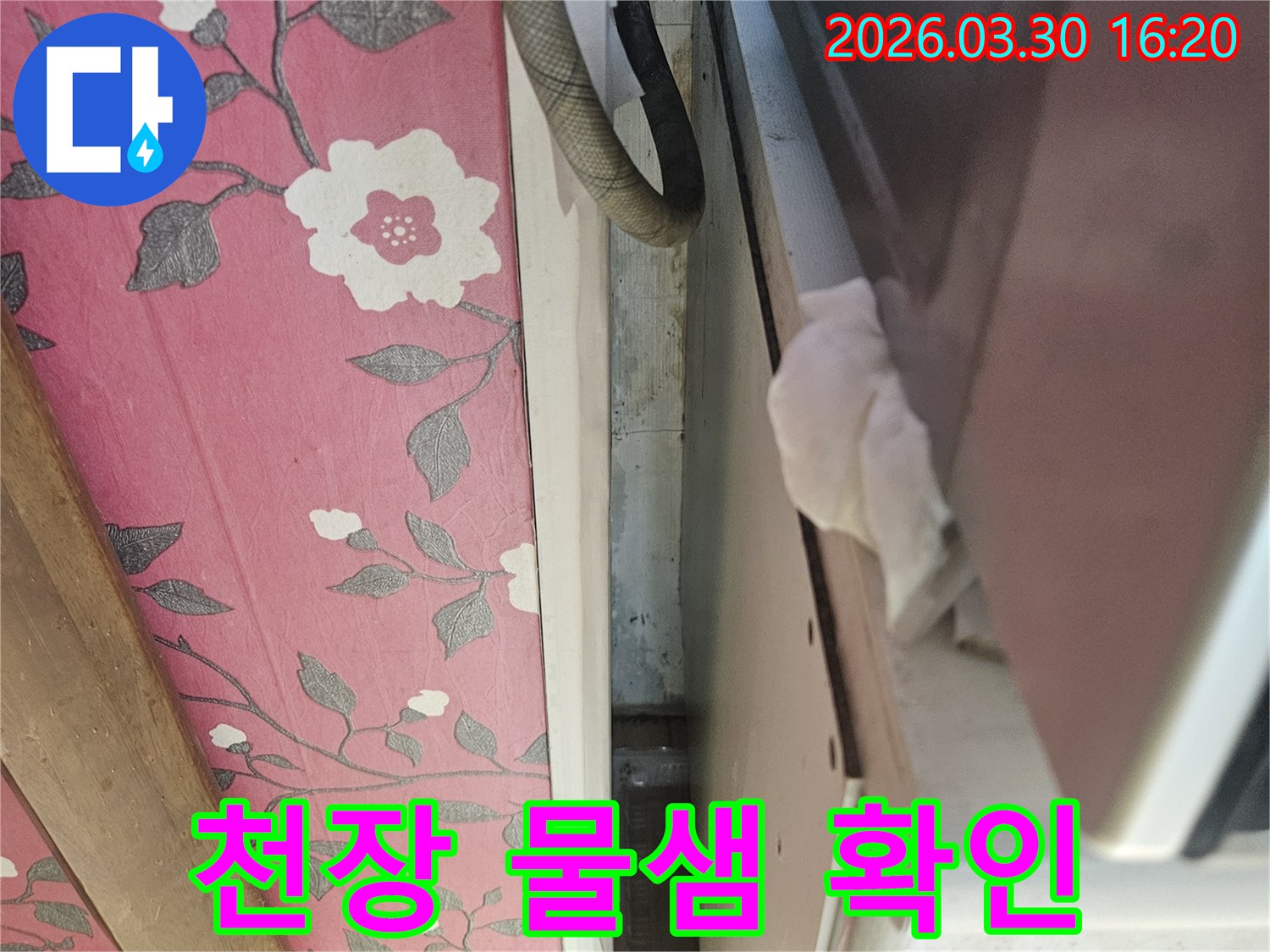이 이미지는-천장-틈새에서-발생한-미세한-물샘을-보여주며-젖은-종이로-누수-여부를-확인하고-있습니다