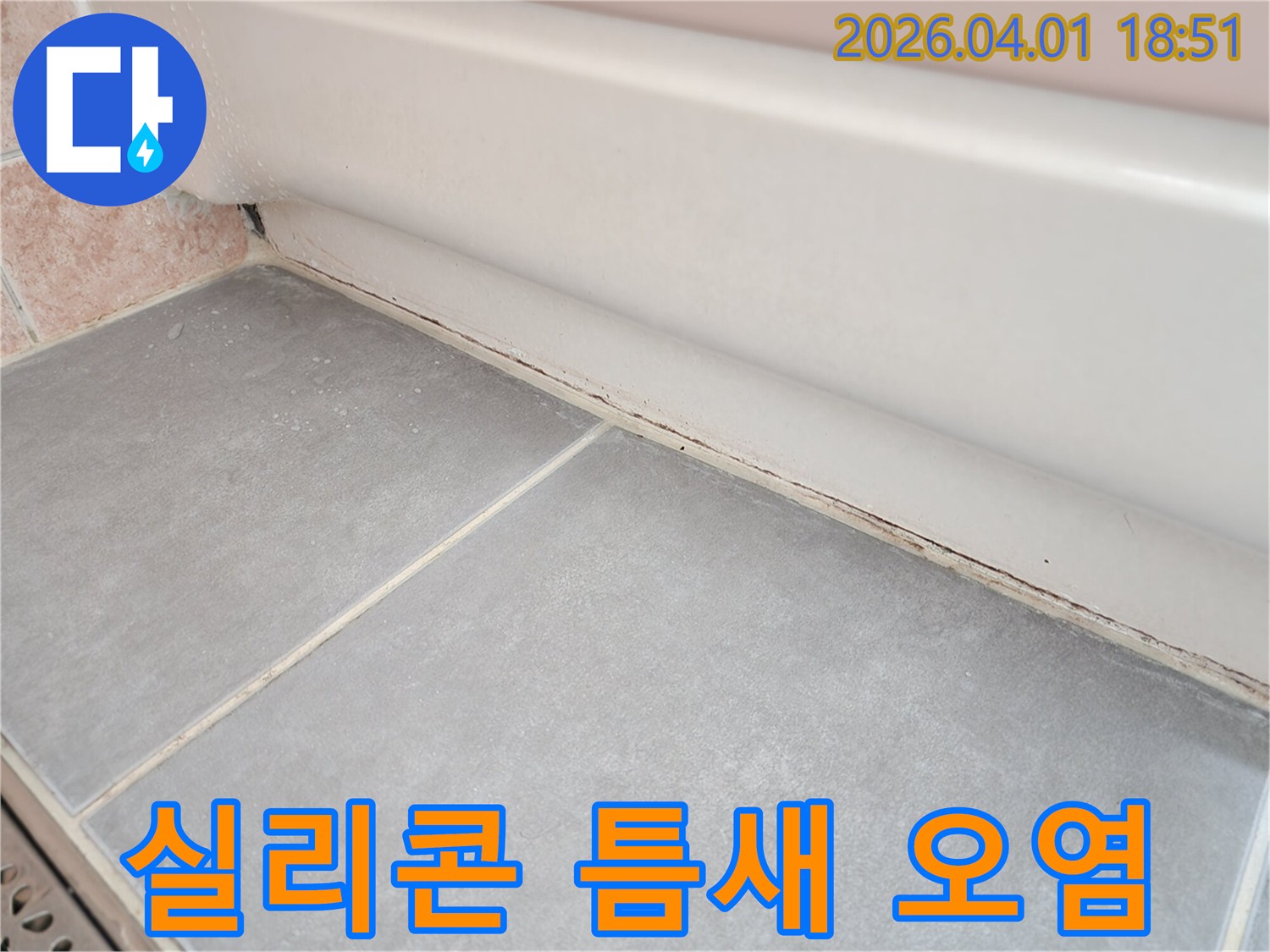 욕실-바닥-타일과-벽면-하단-실리콘-경계에-낀-검은색-곰팡이와-오염을-자세히-보여주는-이미지입니다