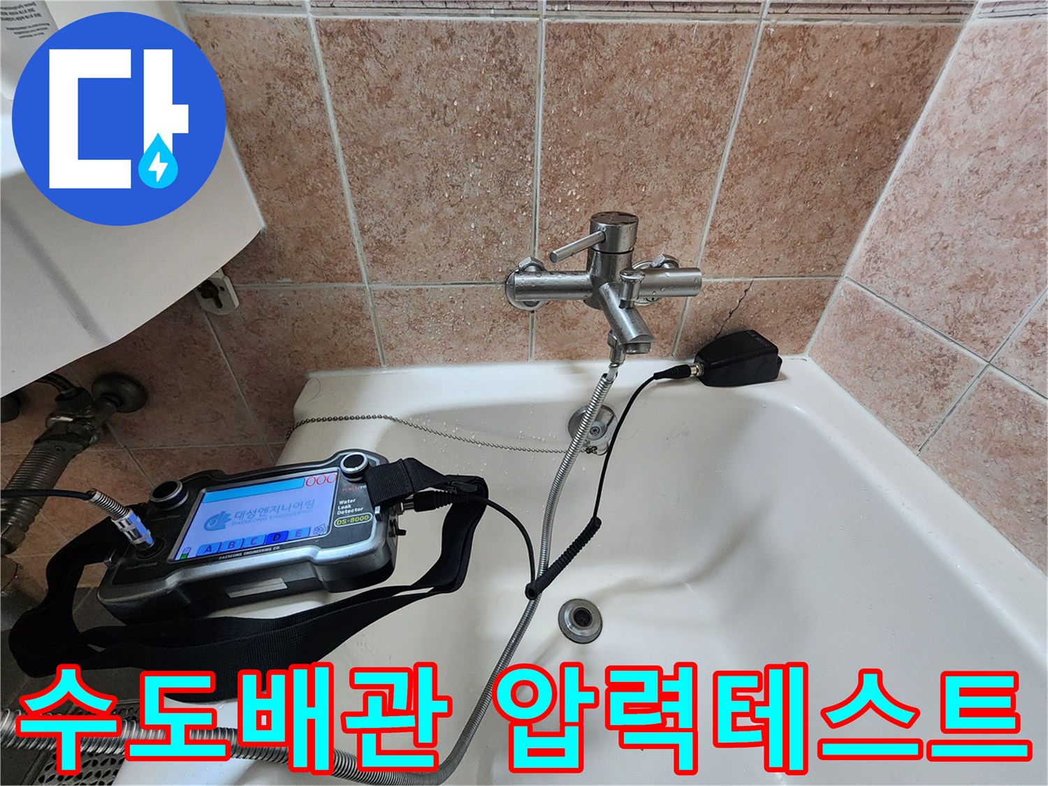 욕실 수전 배관의 누수 여부를 확인하기 위해 전문 장비로 압력을 측정하는 모습