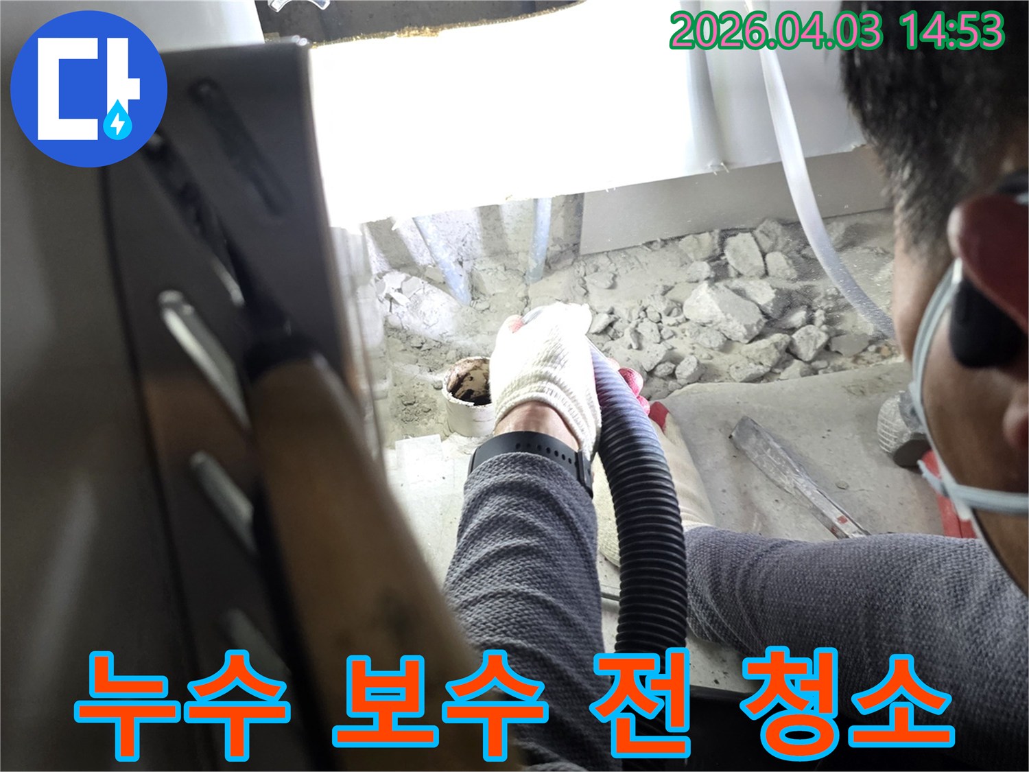 누수 전문 업체 작업자가-보수 작업을 위해 흡입기로 주변을 청소하는 모습