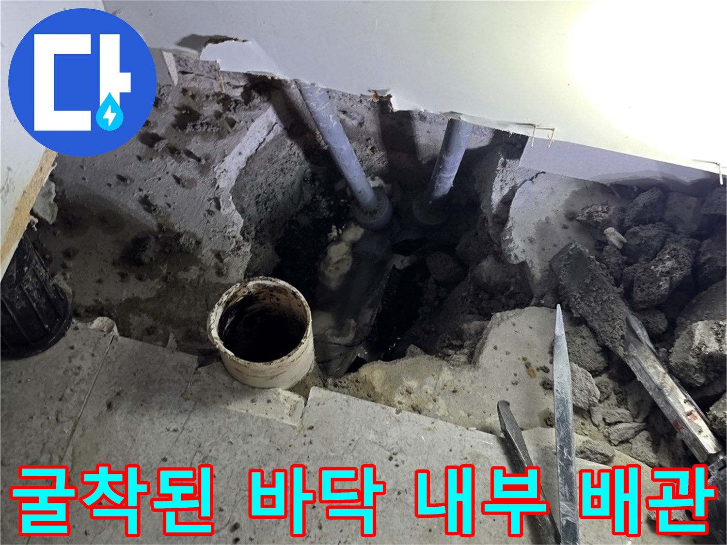 싱크대 하부장 아래 굴착 부위와 노출된 배관 및 작업 도구