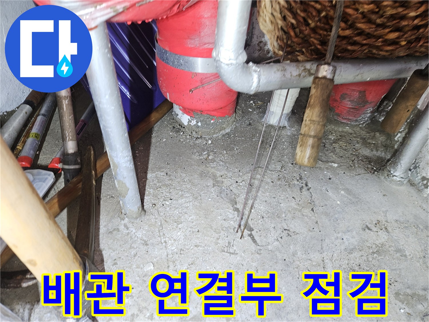 보온재가 감긴 굵은 배관과 주변 금속 파이프의 근접 촬영