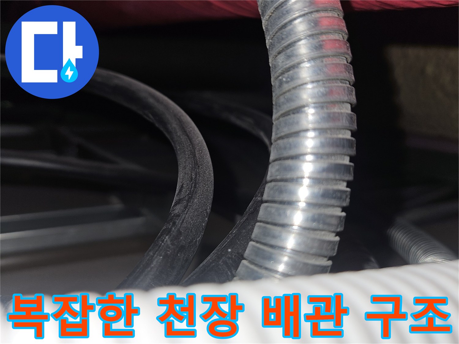 하얀색 주름관과 검은색 전선이 섞여 있는 천장 내부 모습