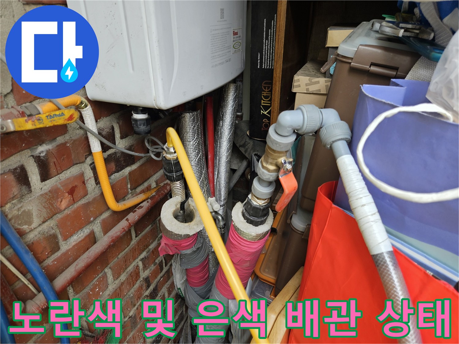 벽돌 벽체 옆에 설치된 보일러 배관과 밸브 장치