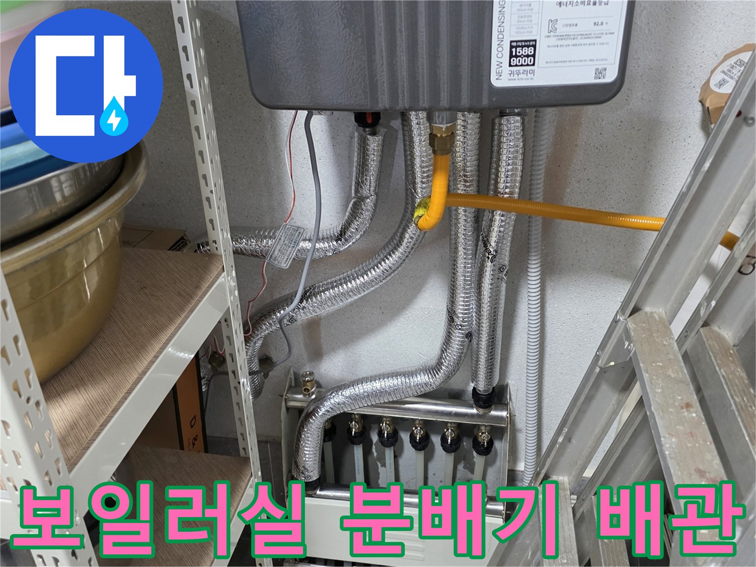 보일러 하단에 연결된 은색 자재의 배관들과 분배기 모습입니다.