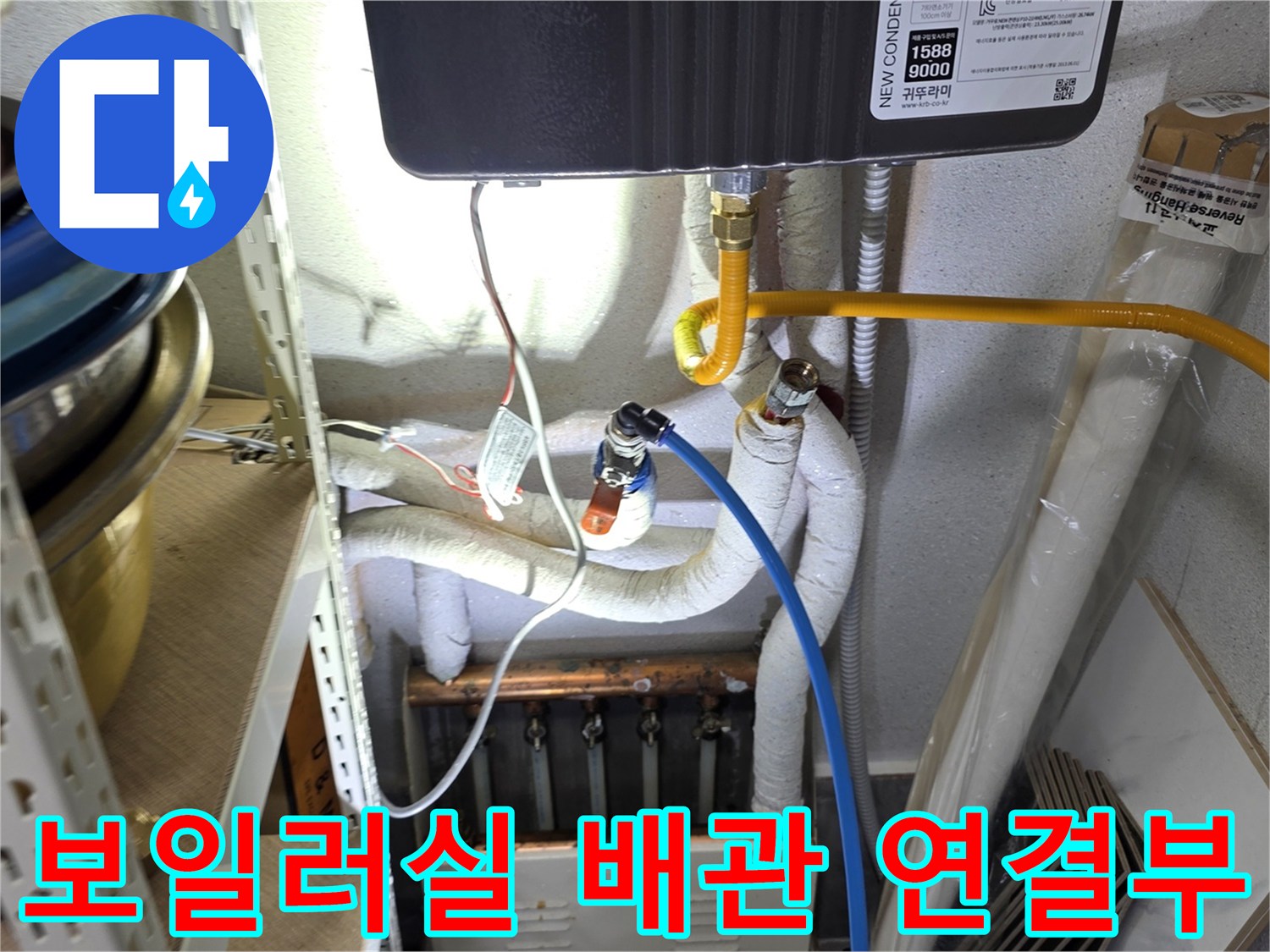 보일러 하부의 노란색 배관과 흰색 보온재가 감싸진 급수 배관 모습