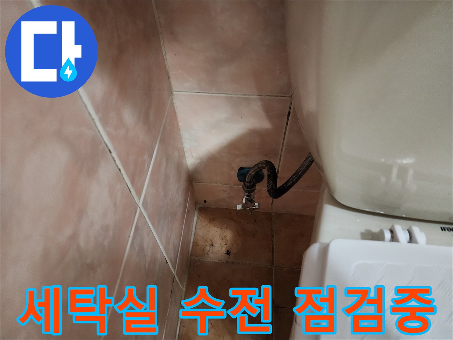 세탁실 벽면에 부착된 수도꼭지와 연결된 호스의 상태를 보여줍니다.
