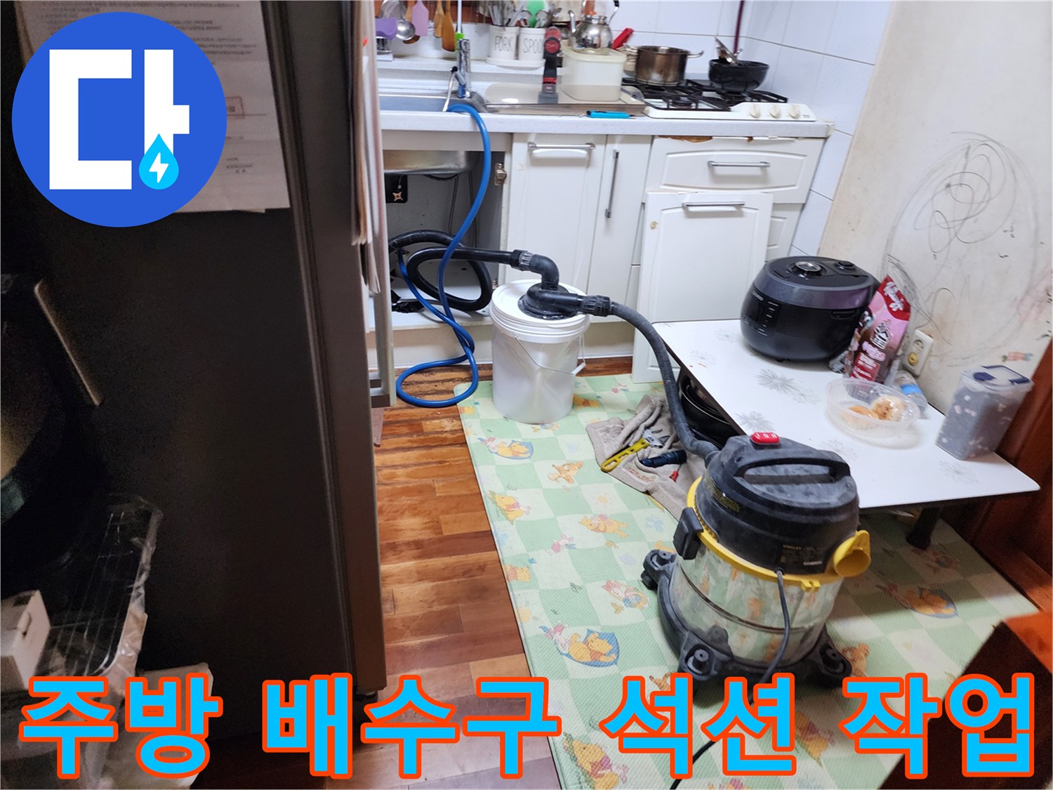 싱크대 아래 배수관의 기름때를 제거하는 석션기 작업 모습
