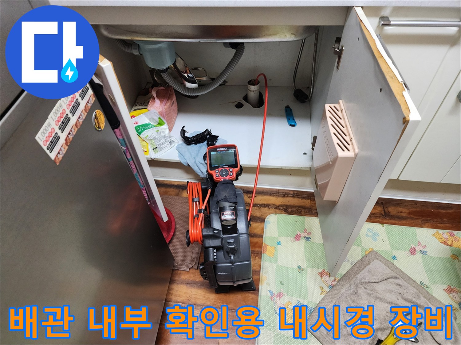 싱크대 하부 배수 호스 주변의 작업 중인 석션기 모습