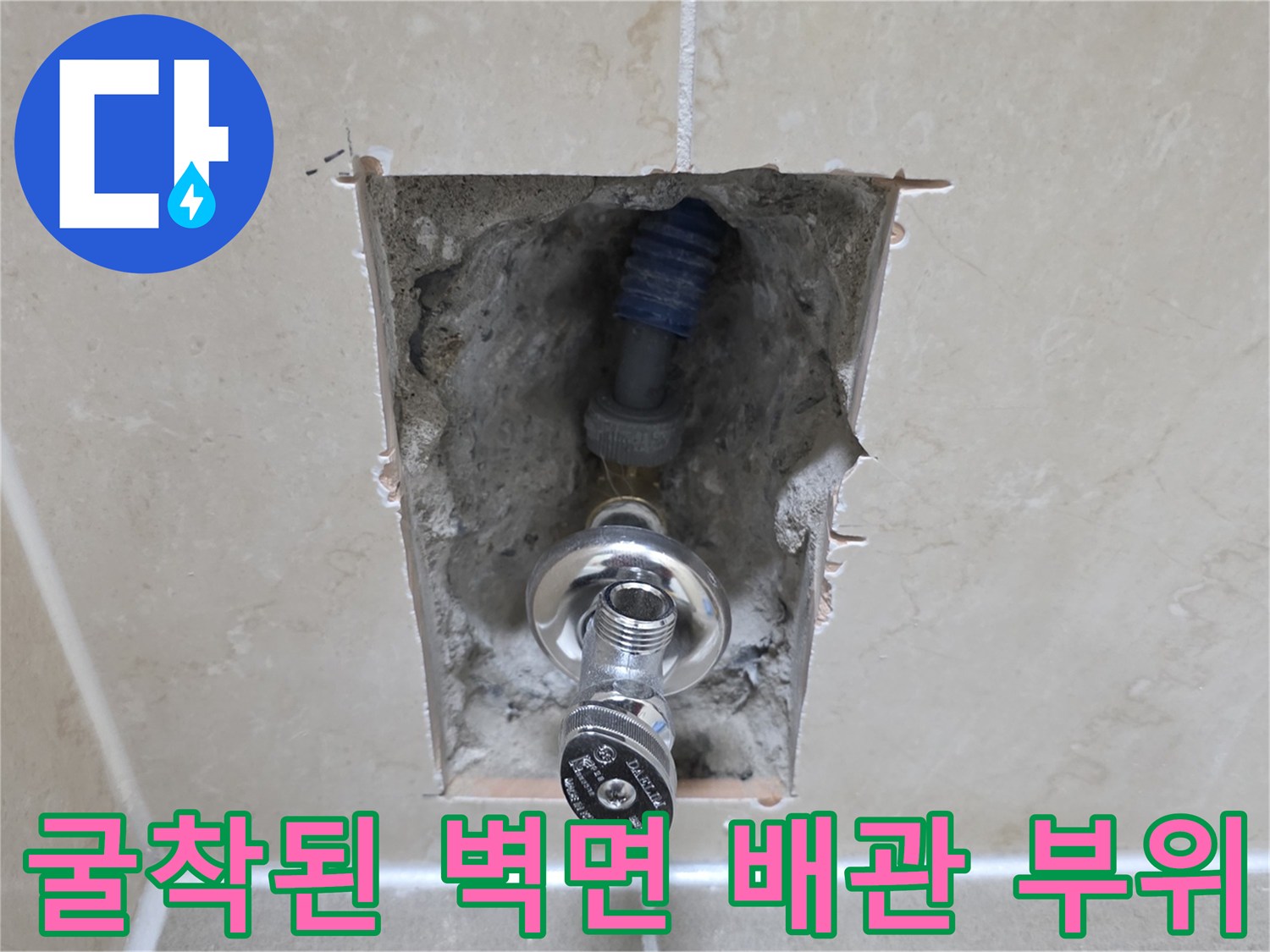 타일 내부 굴착을 통해 노출된 수도 연결 부속과 주름관