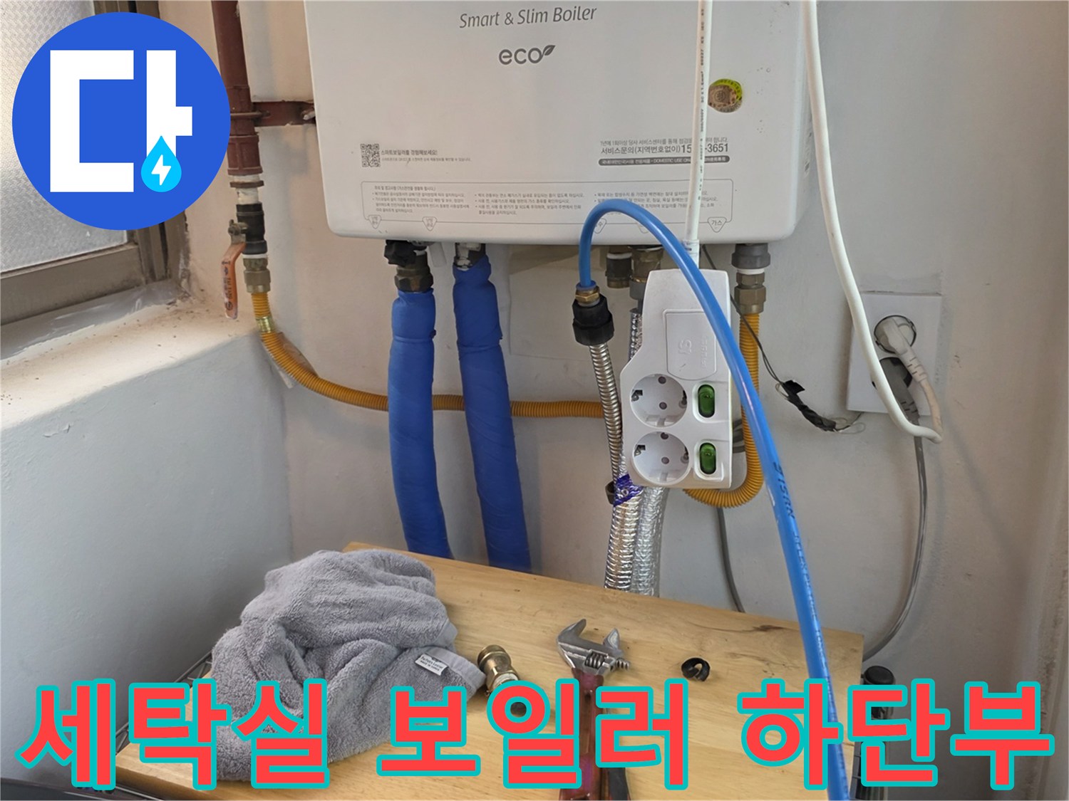 보일러와 연결된 파란색 호스 및 전기 콘센트 근접 촬영