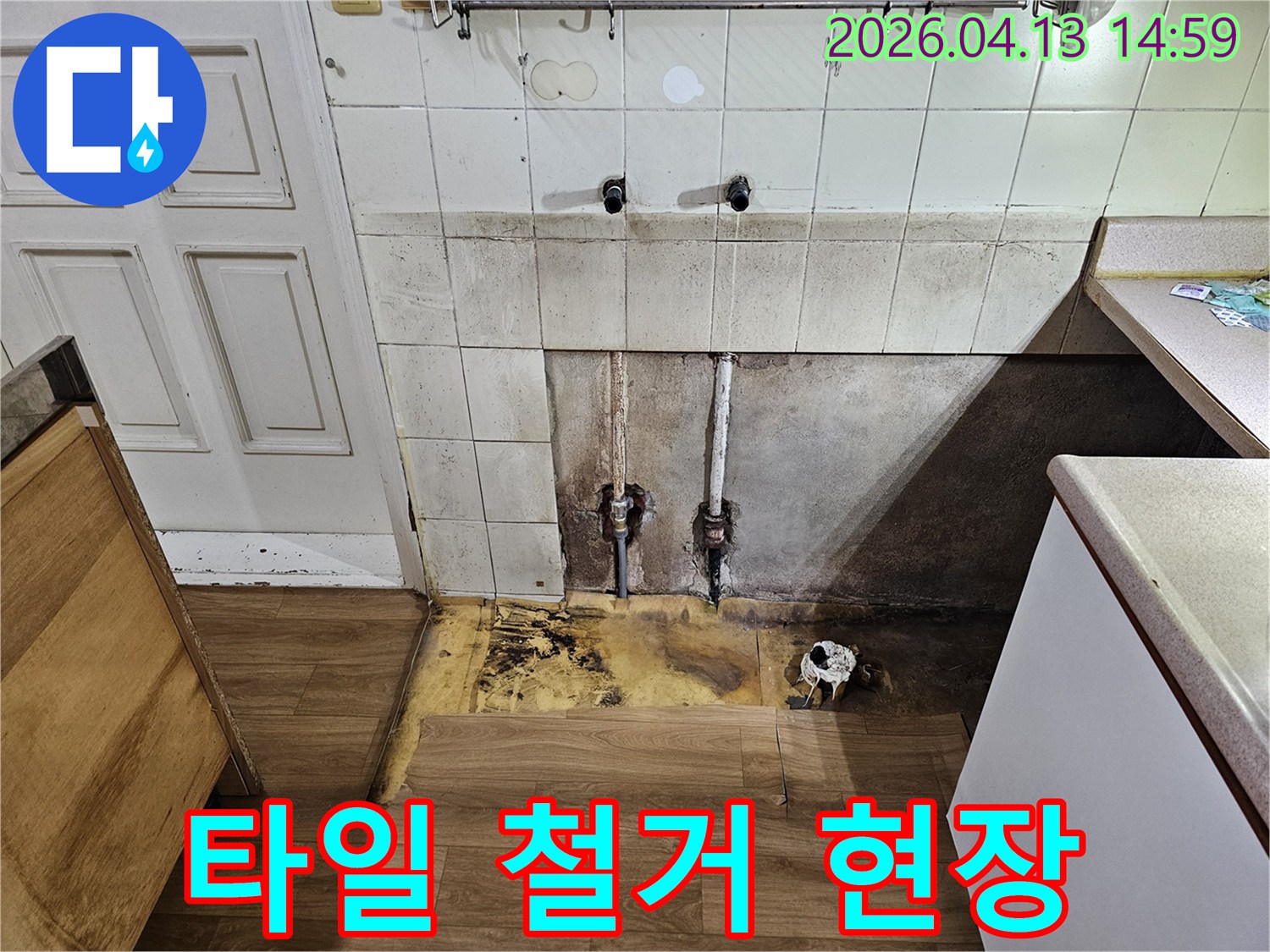 누수 전문가가-싱크대 하부의-심각한 누수 흔적과-바닥 마루의 손상 정도를-고객에게 보여주며-즉각적인 수리 조치를-제안하고 있습니다