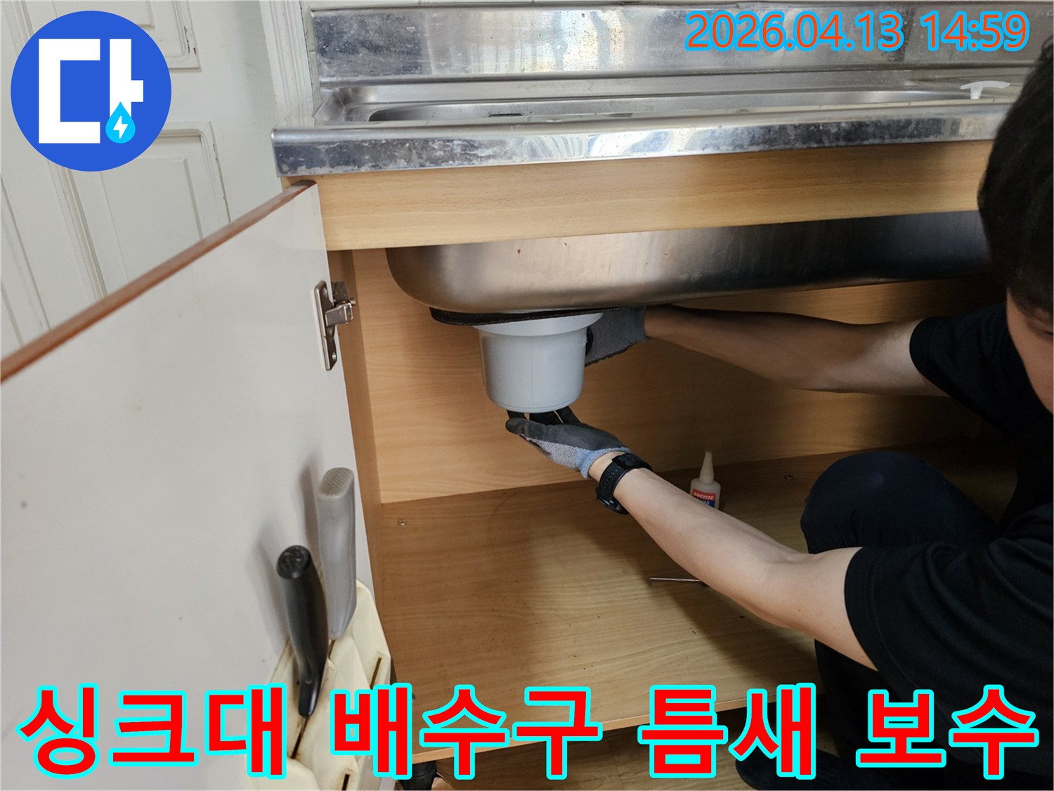 작업자가 싱크대 하부에서-배수구 틈새를 정밀하게 보수하고 있습니다.