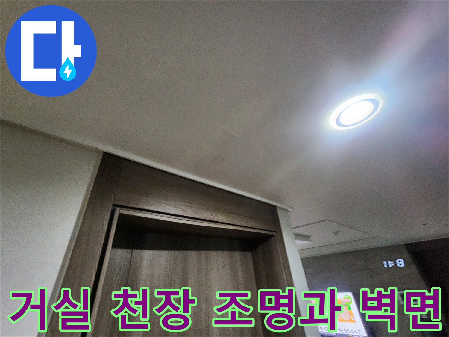 밝은 매립형 조명이 설치된 거실 천장과 나무 무늬 마감재 부근의 모습입니다.