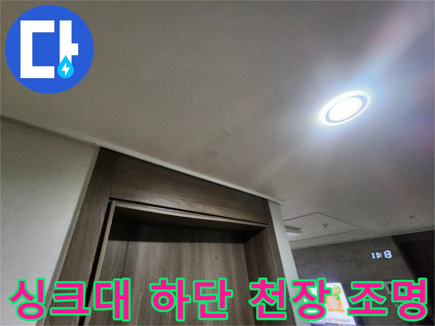 주방 싱크대 하부장 위쪽 천장의 매립형 LED 조명과 벽면 마감재 모습입니다.