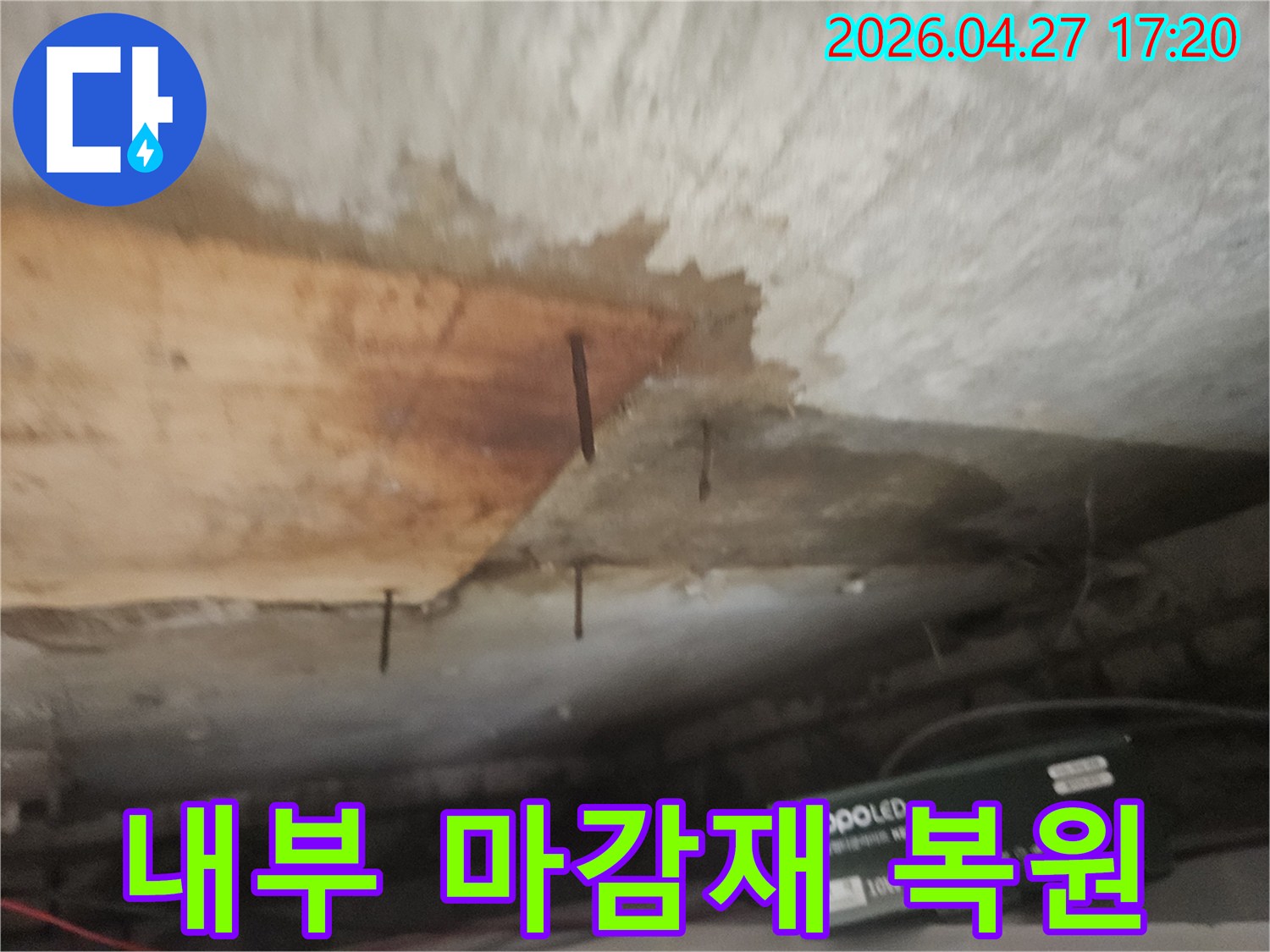 누수로 인해 천장 마감재가 떨어지고-나무 구조물과 녹슨 못이 노출된 상태입니다.