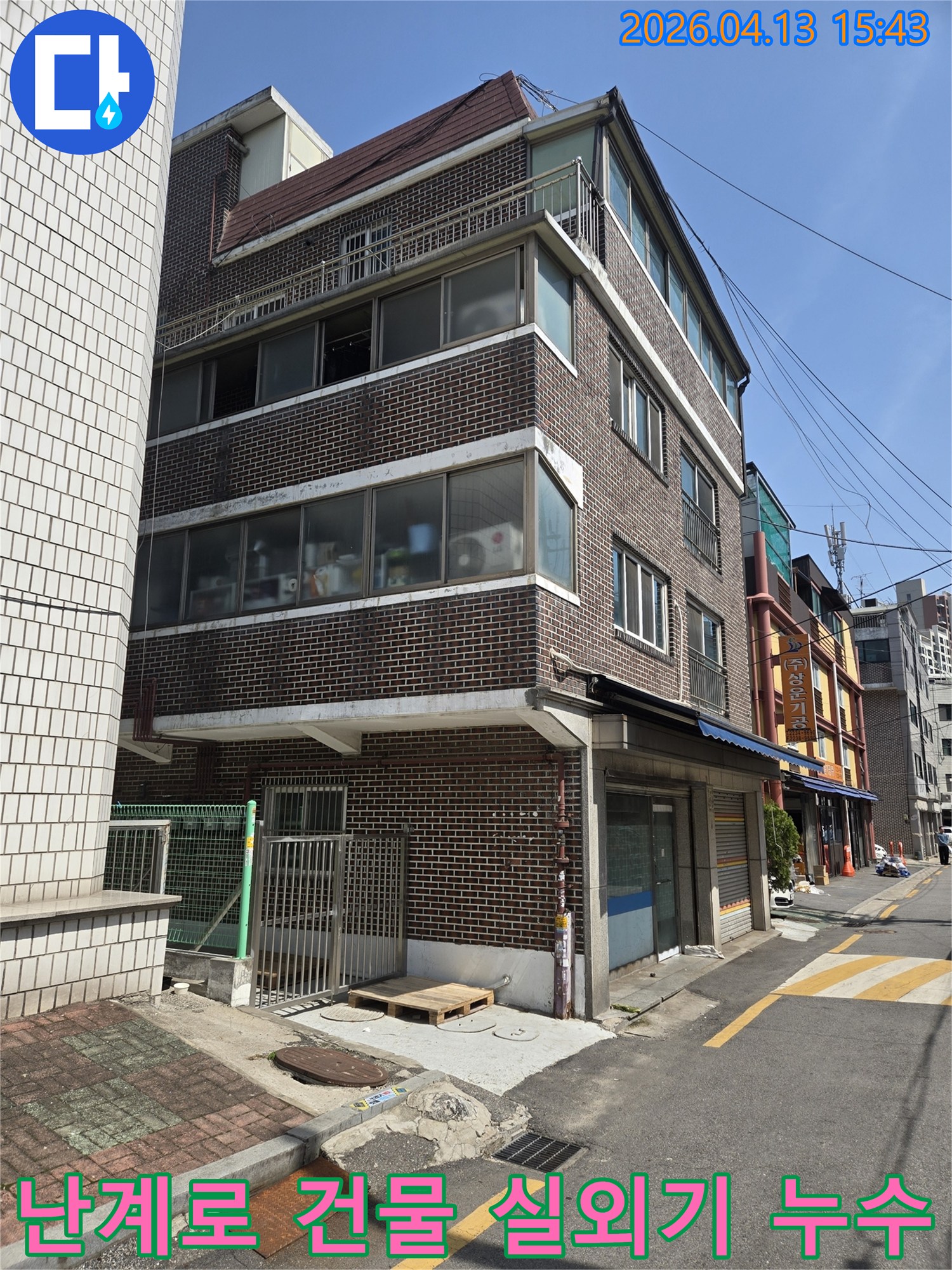 난계로의-건물-외관을-보여주는-이-사진은-외부-에어컨-실외기-배관-문제로-인한-누수-원인을-찾기-위해-전문-엔지니어가-현장을-점검하는-모습입니다.