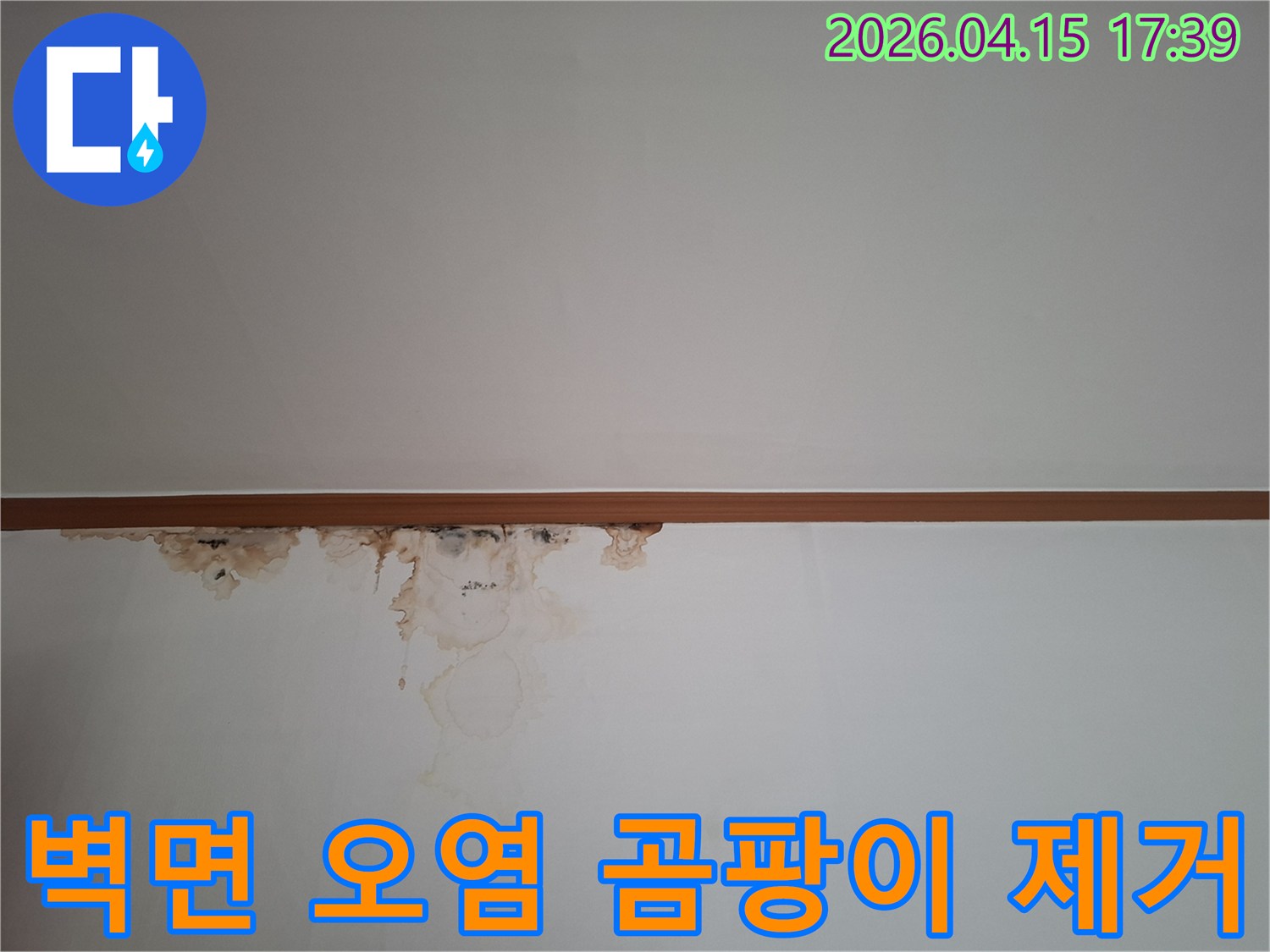 천장과 벽이 만나는 경계선에-누수로-인한-물자국과-곰팡이가-생겨-벽지가-심하게-오염된-모습을-보여주는-사진입니다
