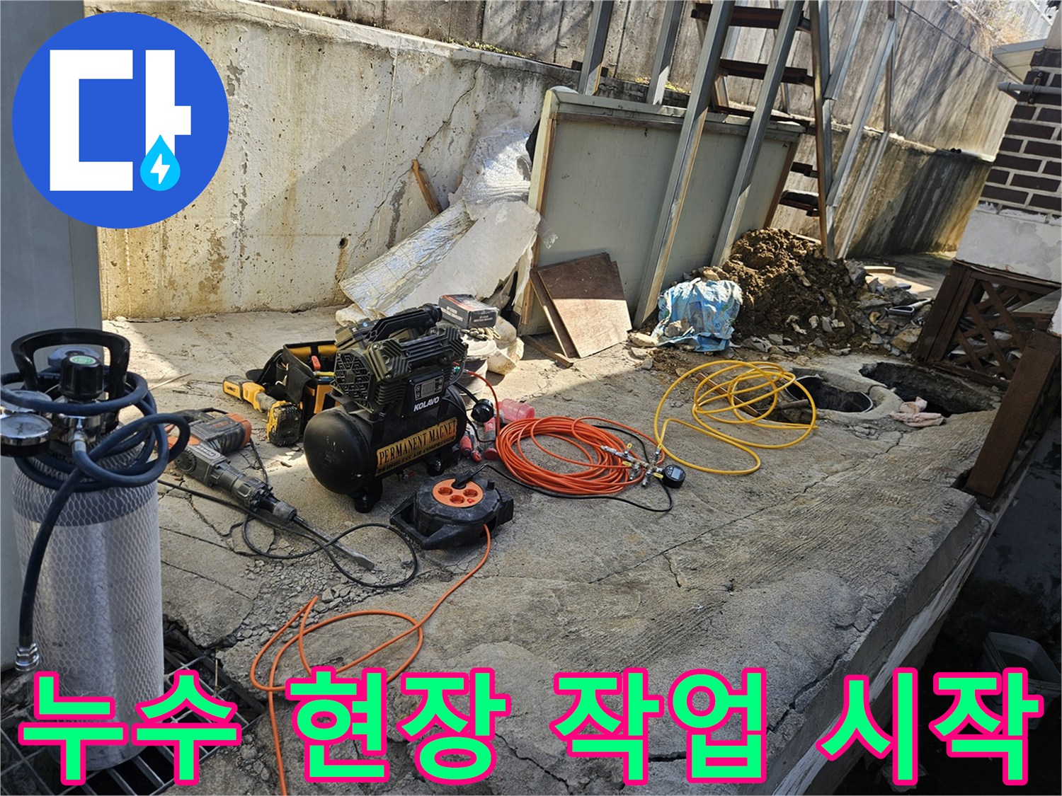 누수 공사 현장에서-에어 콤프레셔-함마드릴-호스-전선릴 등-다양한 전문 장비들이-콘크리트 바닥 위에-정돈된 채-작업 시작 전-준비를 마친 모습