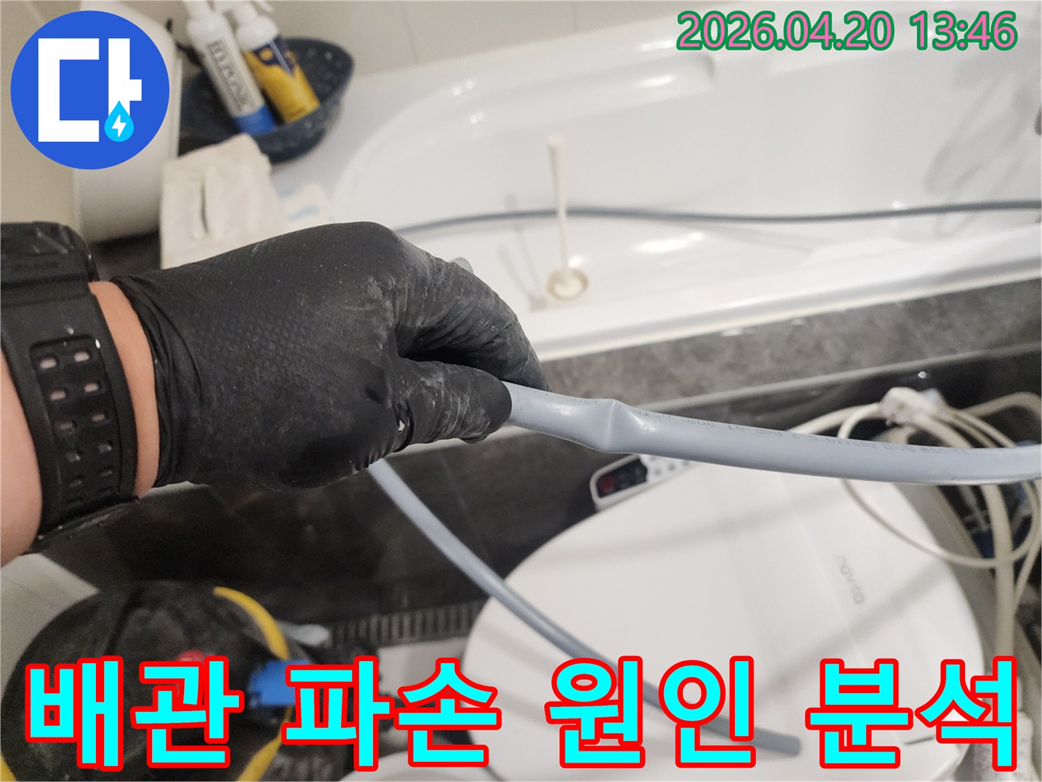 누수 전문 엔지니어가 검은 장갑을 끼고-화장실 배관의 파손 여부를 확인하며-누수의 근본적인 원인을 분석하고 있습니다.