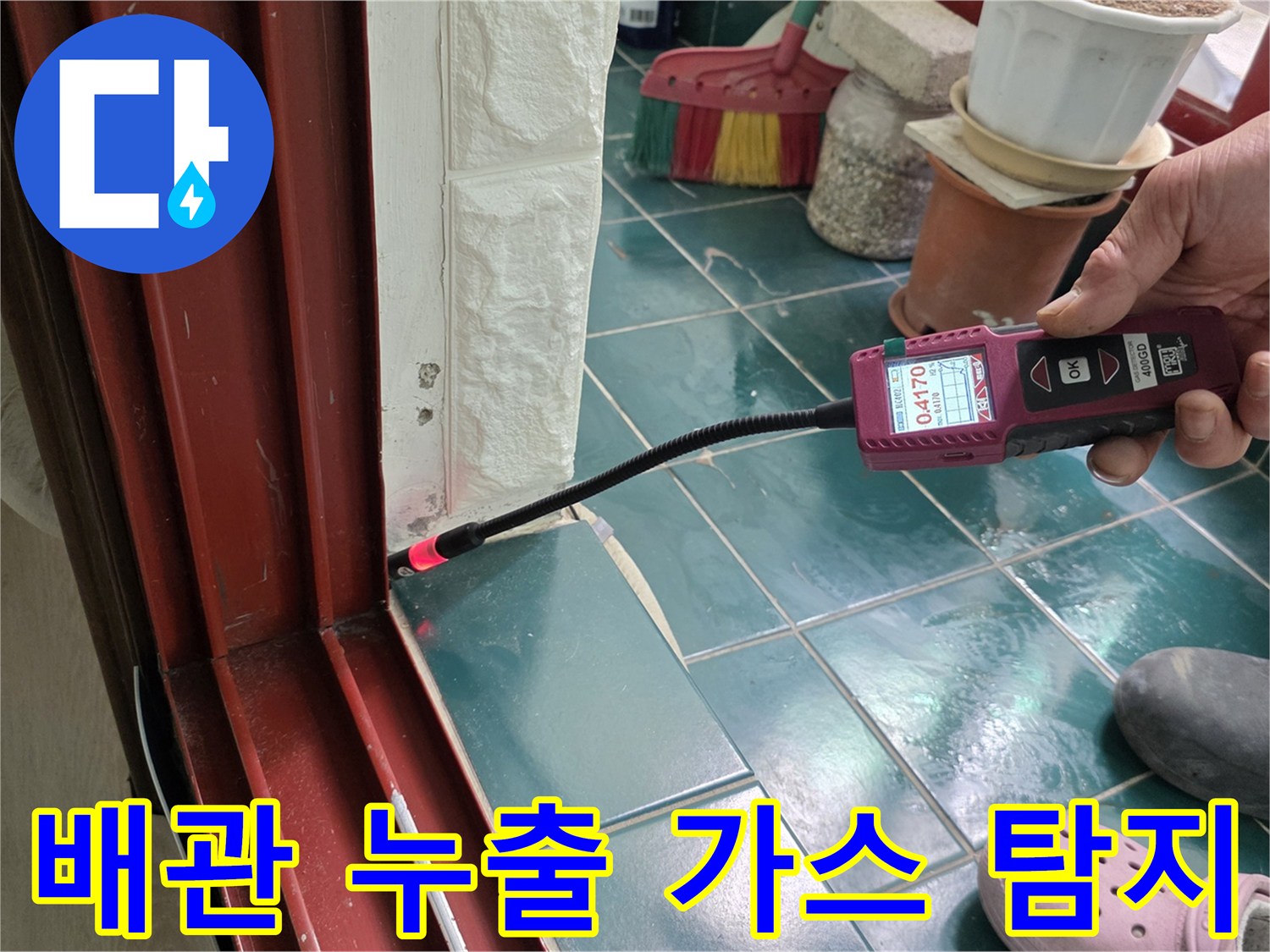 가스 탐지 장비의-프로브를 타일 틈새에 대고 누수 지점을 찾는 현장 사진