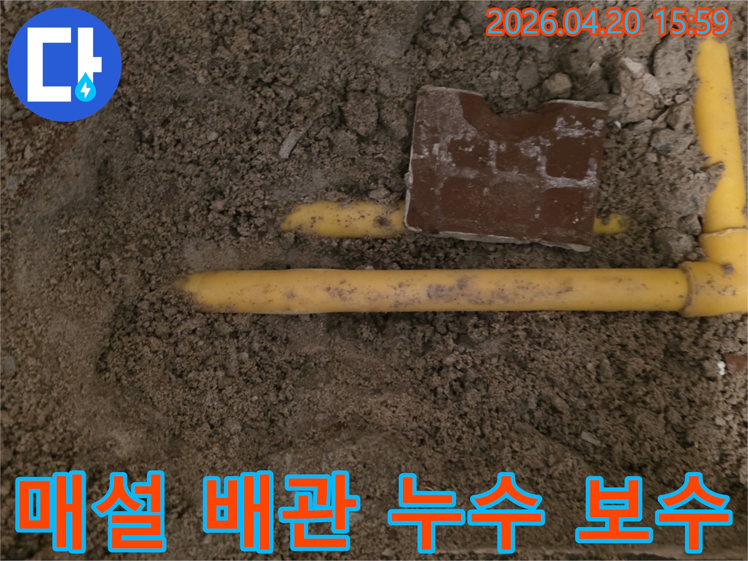 흙 속에 묻힌 노란색 배관에서-누수 지점을 찾아내어 보수 작업을 준비하는 현장입니다