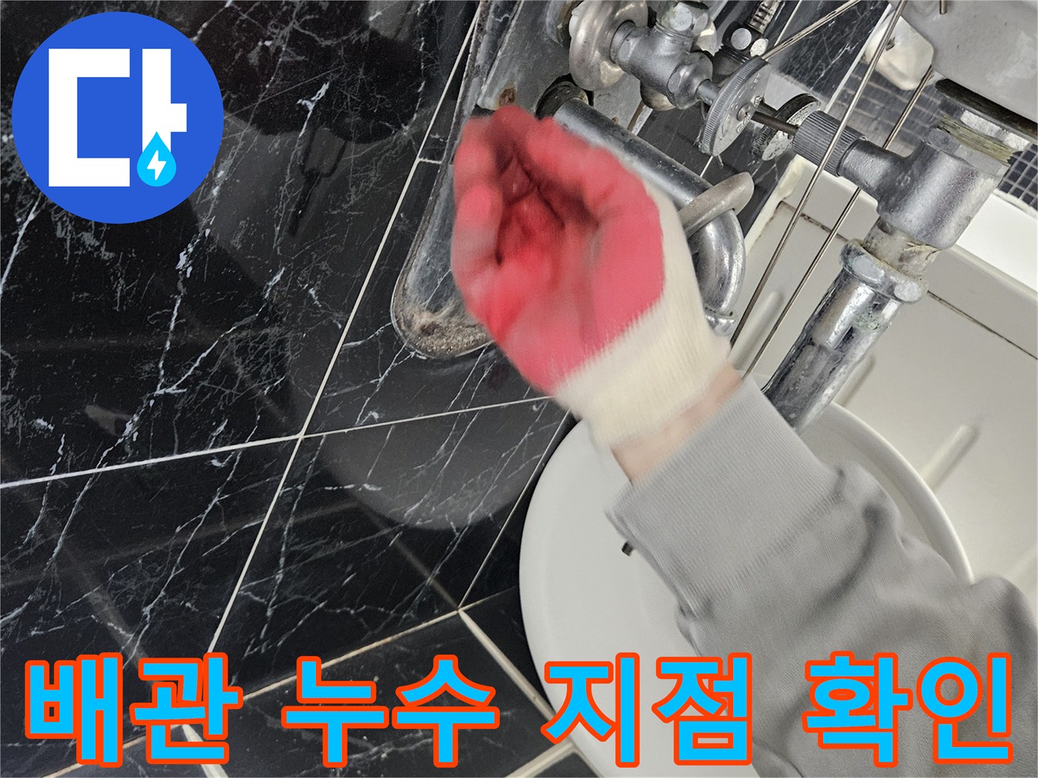 싱크대 아래쪽의 젖은 배관 부위를 손으로 만져보며 점검하는 사진