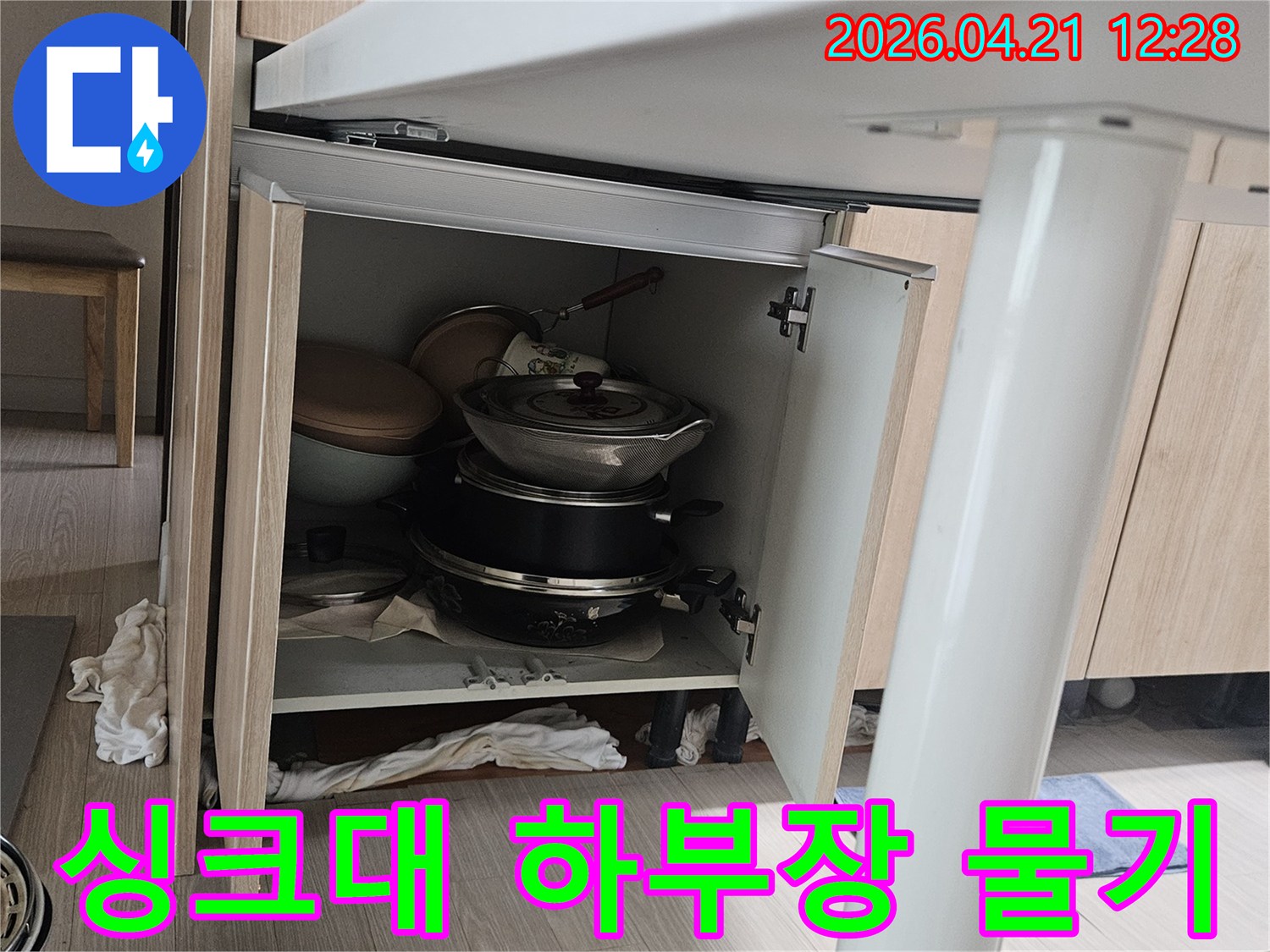 싱크대 하부장 내부에서 발견된-물기로 젖은 주방용품과-배관 노후로 인한 누수 현장