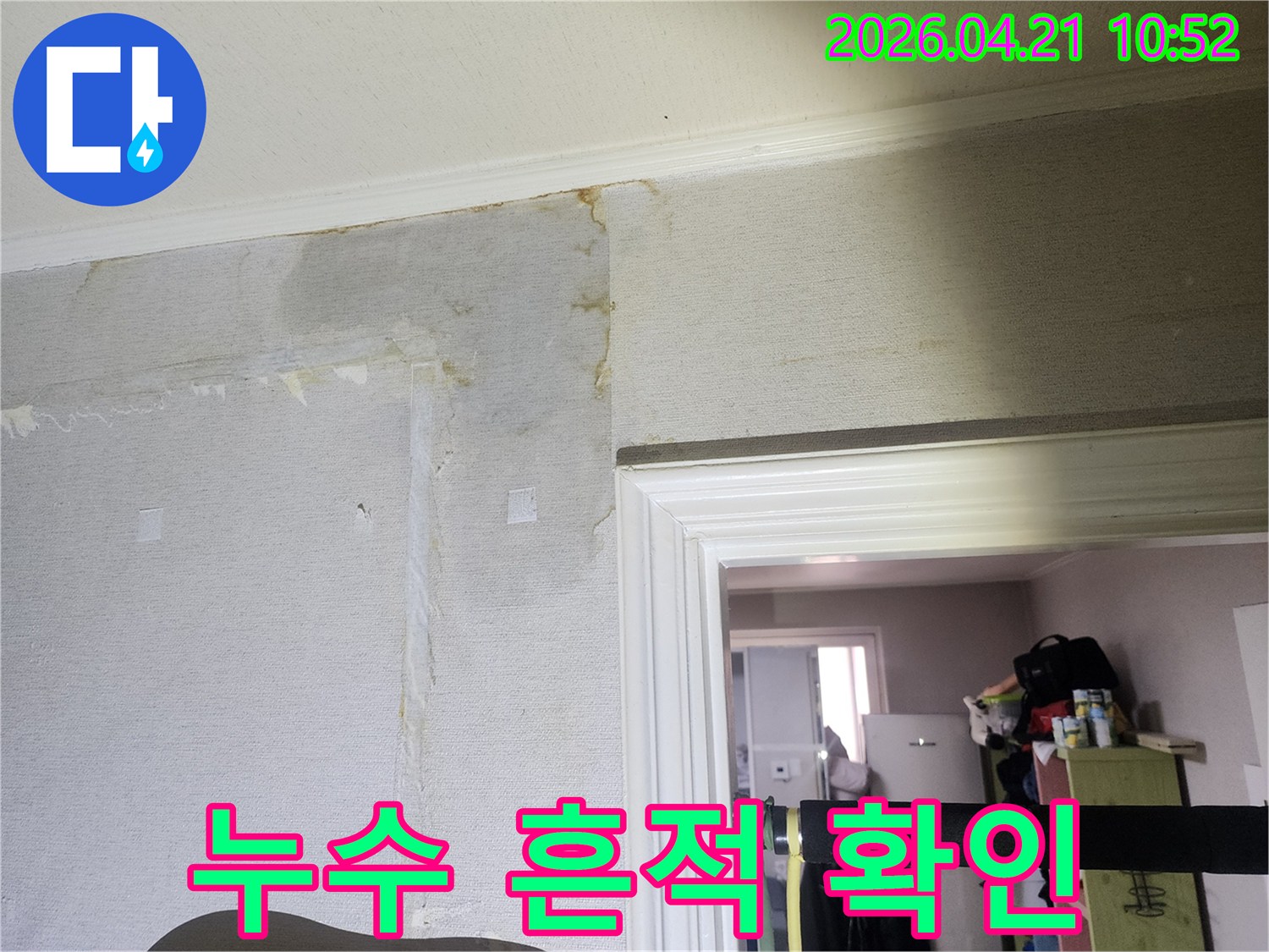 천장과 벽면의 경계 부위에서 물이 새어 벽지가 젖고 변색된-누수 피해 상황을 상세히 보여줍니다.