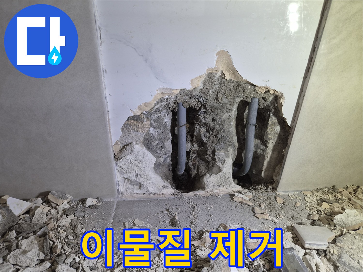 누수 공사 중- 벽을 파쇄하며 발생한- 배관 주변 이물질을 제거하는 모습입니다