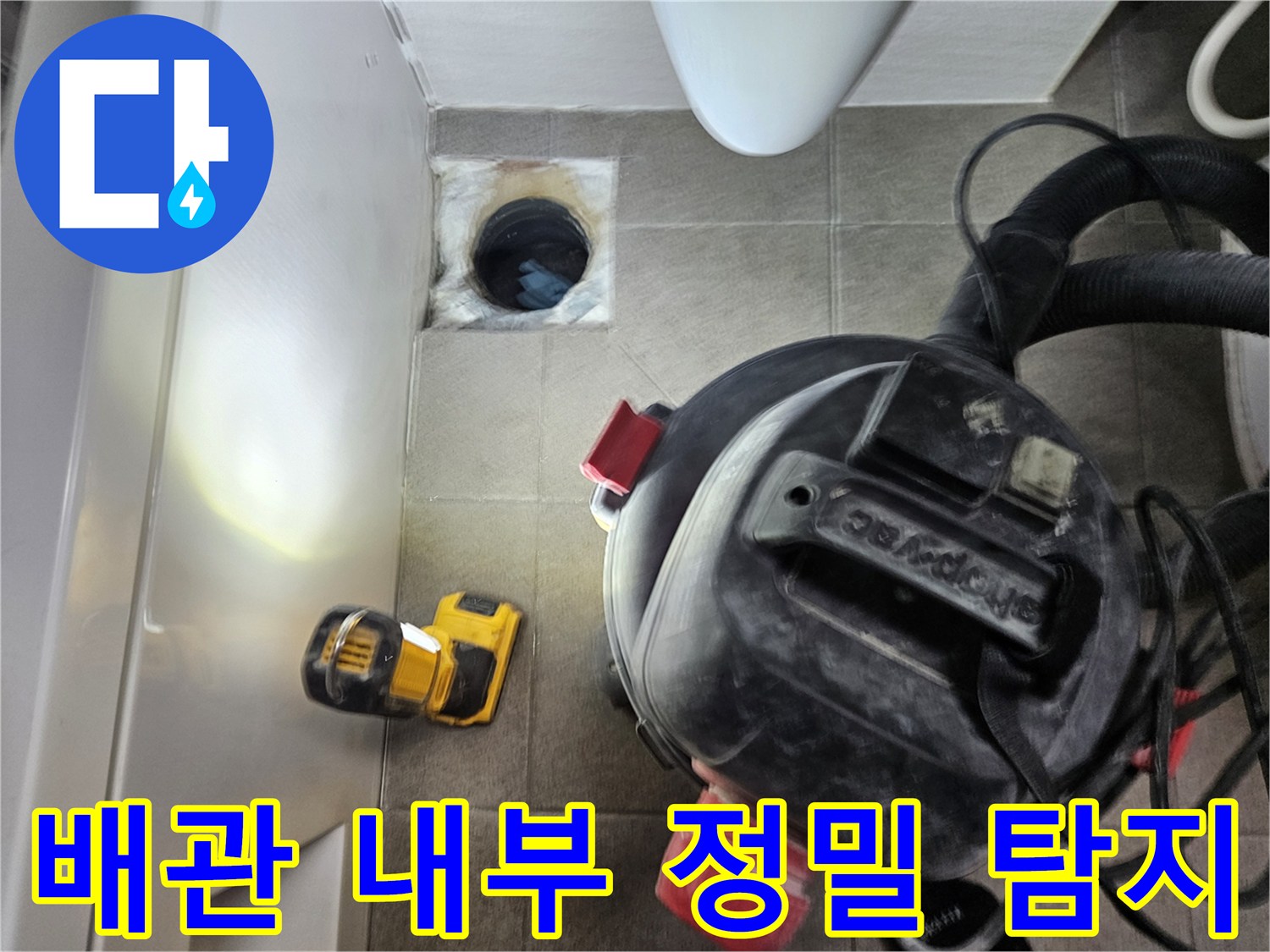 누수 엔지니어가-오산시티자이2차-아파트 욕실의-어두운 배관 속을-손전등으로-밝히며-누수 원인을-찾는-모습
