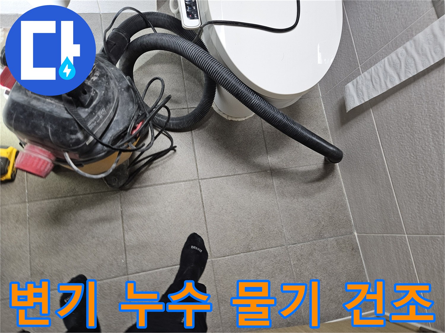 오산시 고객 댁 화장실에서-누수 엔지니어가-변기 주변의 물기를-습식 청소기로 제거하며-누수탐지를 위한-바닥 건조 작업을 진행하는 모습