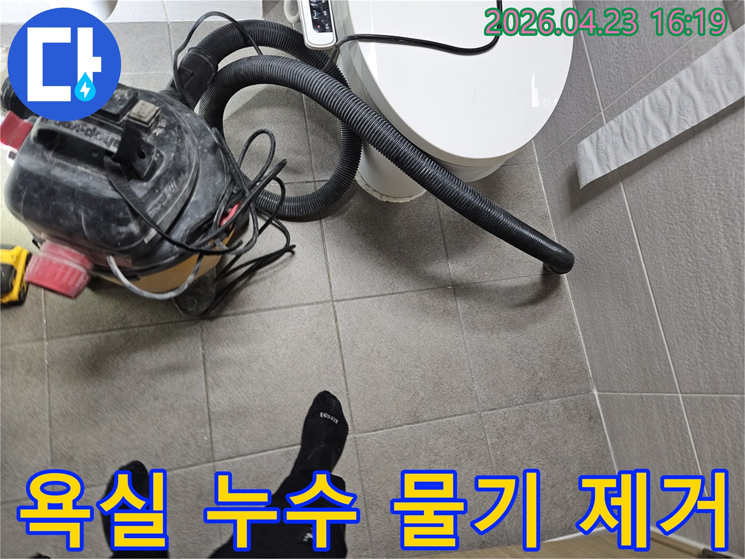 오산시 고객 댁 화장실에서-누수 엔지니어가-변기 주변의 물기를-습식 청소기로 제거하며-누수탐지를 준비하는 모습